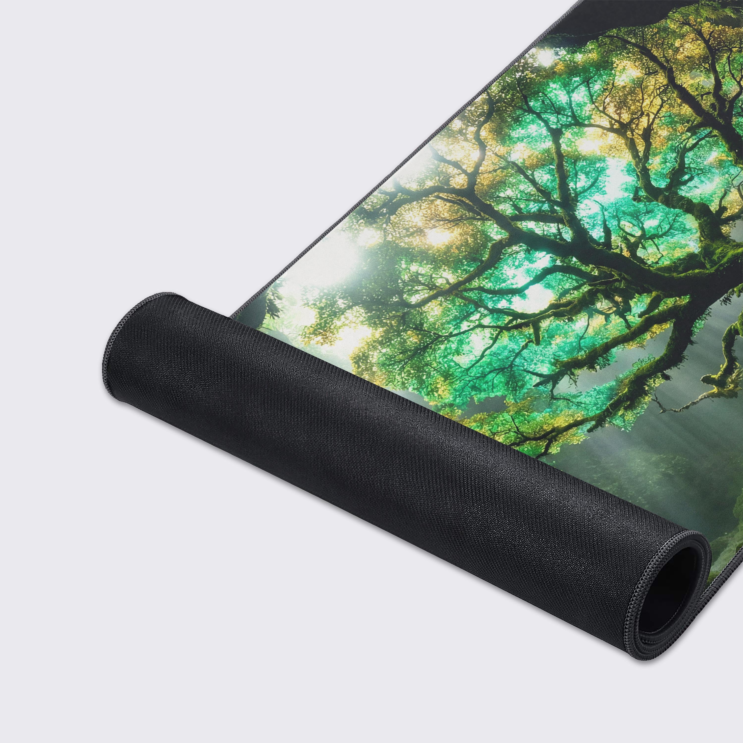 A close-up of the Cavern Light gaming desk mat, highlighting the high-quality fabric texture and durable stitched edges surrounding the magical mossy tree artwork. - Epic Design Pads & Mousepads