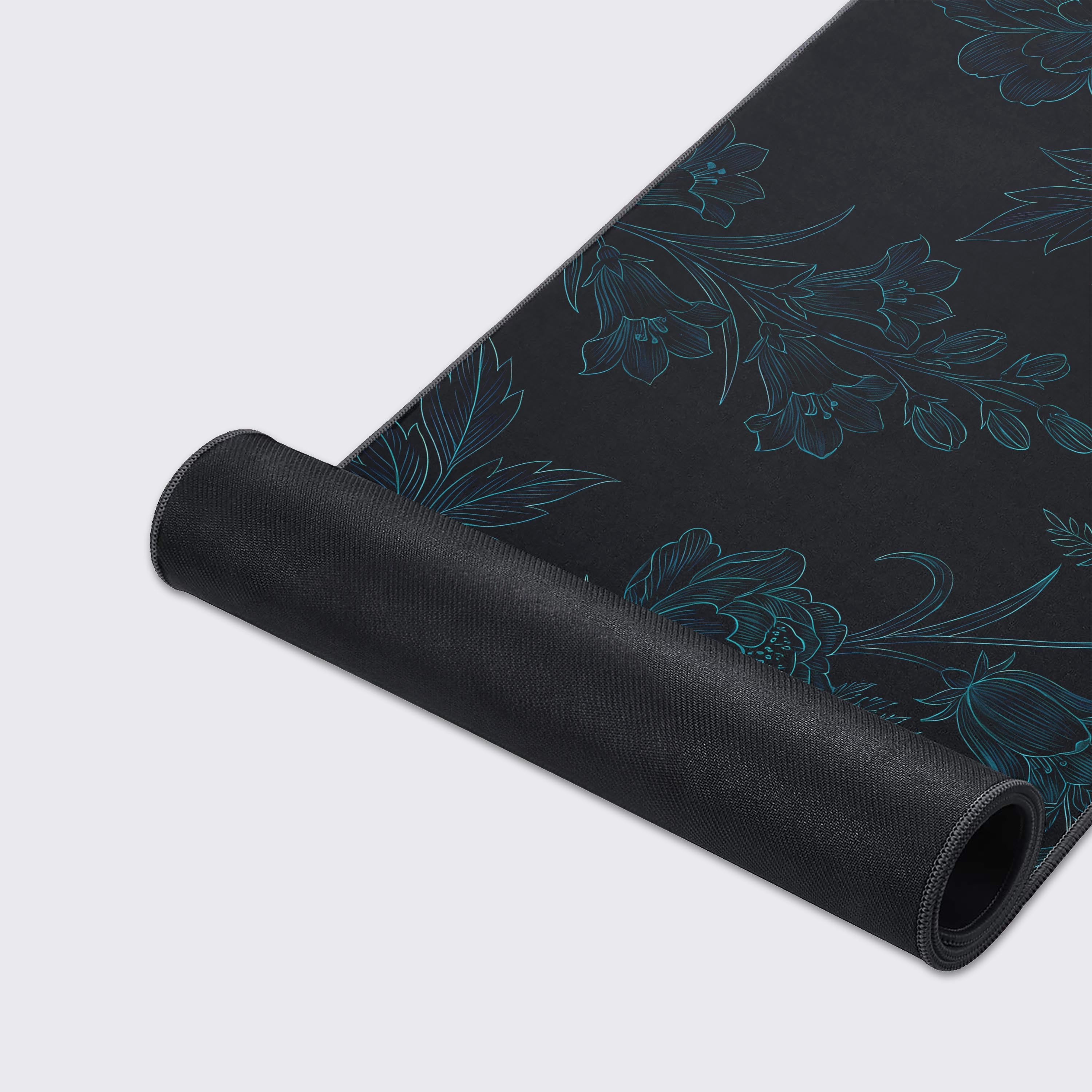 Close-up of the Shadow Bloom gaming desk mat showing the smooth texture and durable stitched edges, highlighting the intricate teal floral line art design. - Epic Design Pads & Mousepads