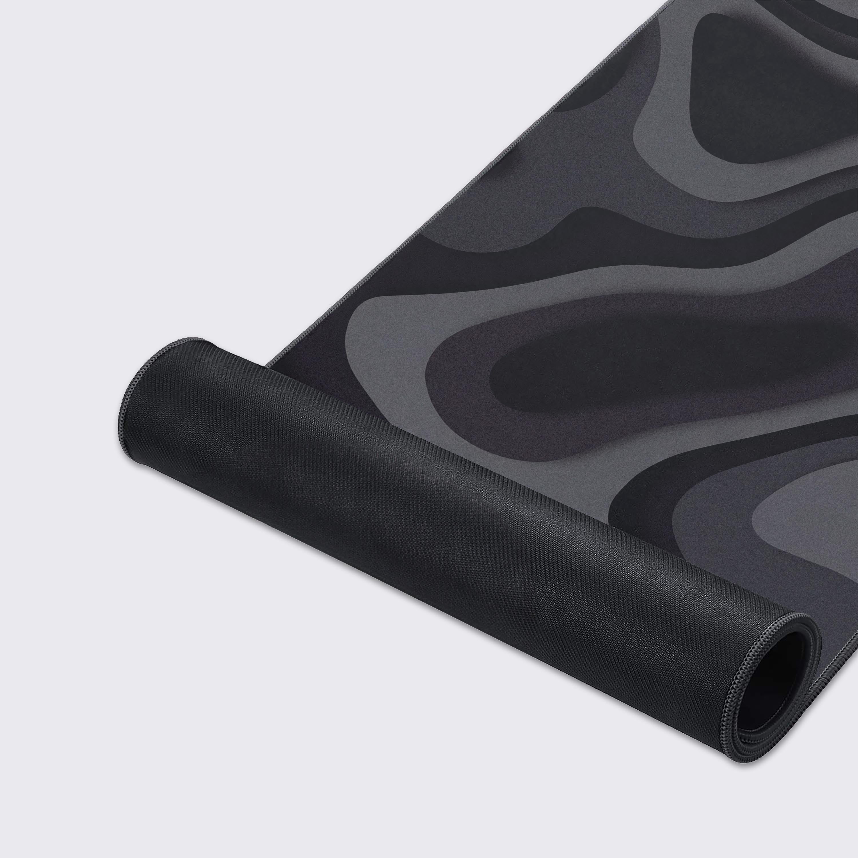 Close-up of the Obsidian Strata gaming desk mat, showcasing the smooth fabric texture and durable stitched edges of the dark, topographic-inspired design. - Epic Design Pads & Mousepads