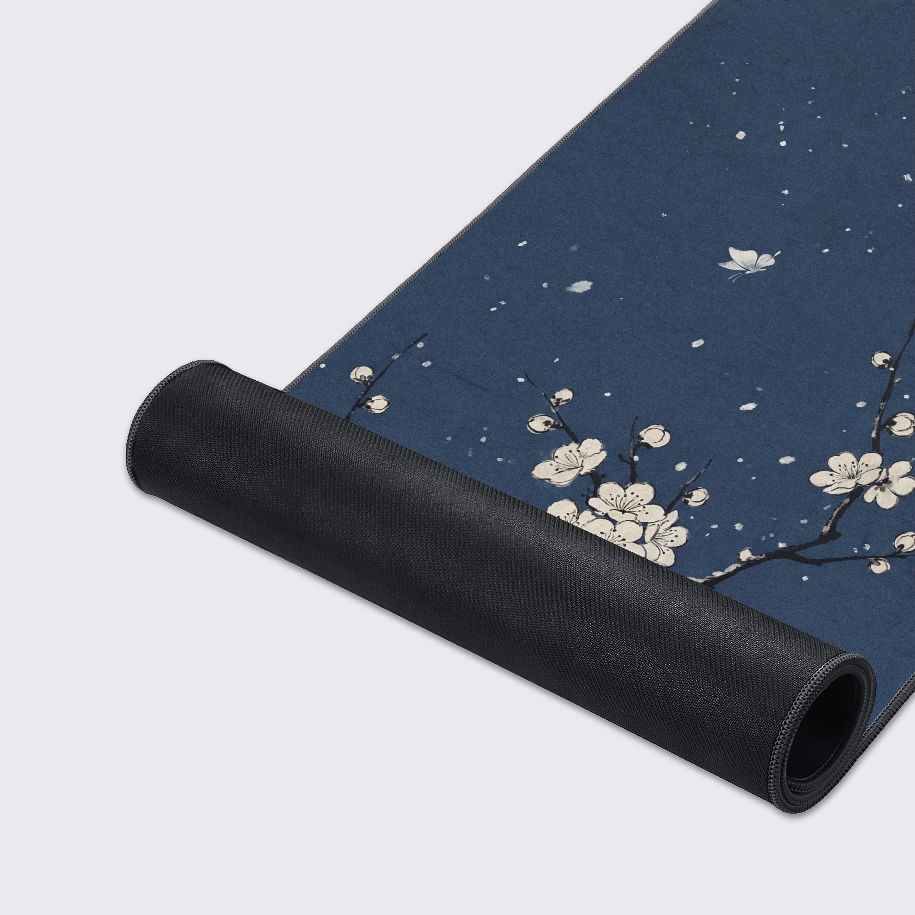 Close-up of the Indigo Sakura gaming desk mat highlighting the smooth fabric texture and durable stitched edges, with the elegant white cherry blossom art visible. - Epic Design Pads & Mousepads