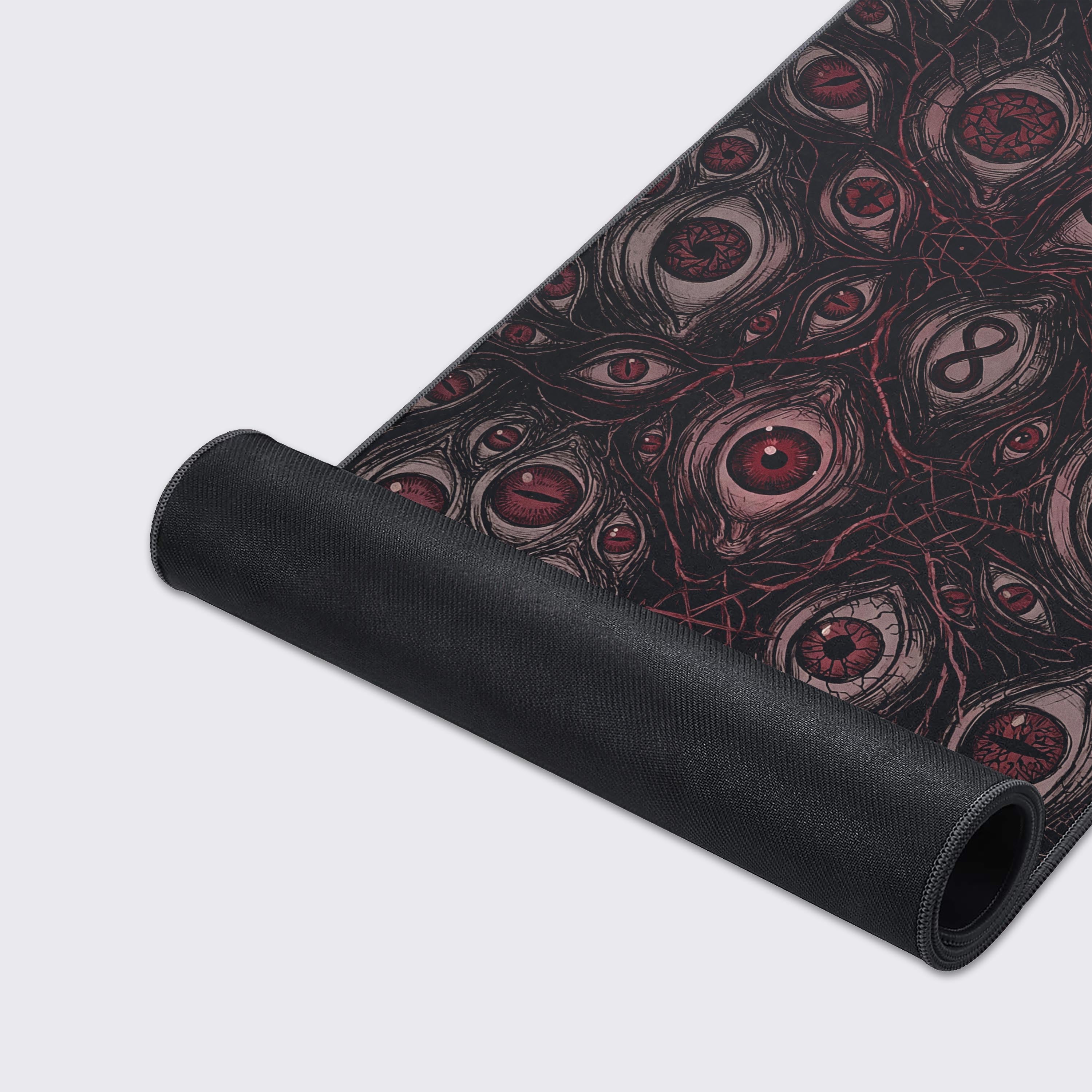 A close-up of the Omniscient Abyss gaming desk mat, highlighting the high-quality fabric texture, stitched edges, and the detailed, unsettling red eye artwork. - Epic Design Pads & Mousepads