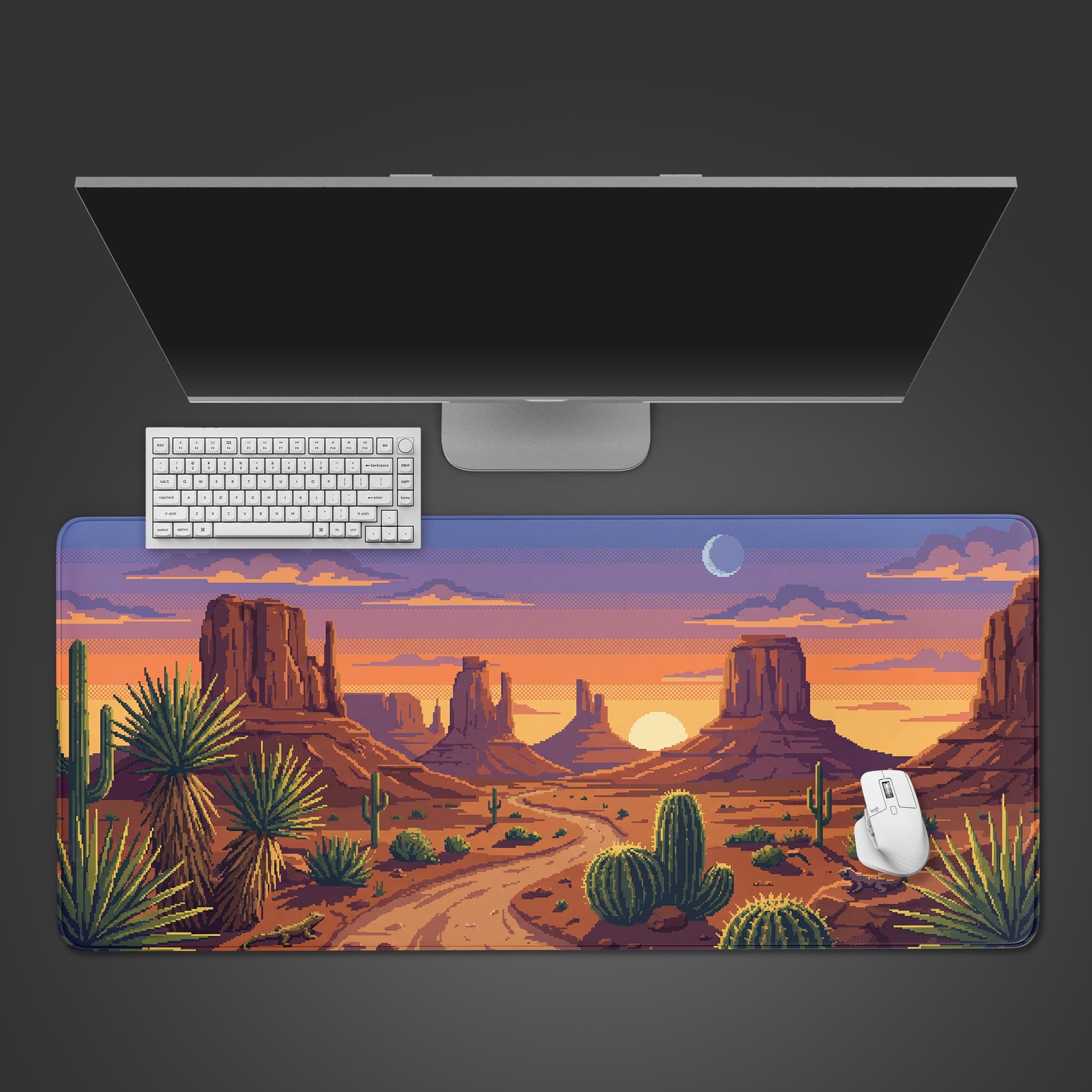 Top-down view of the 8-Bit Dusk Gaming Desk Mat, featuring a pixel art desert landscape, shown with a white keyboard, mouse, and monitor on a dark surface. - Epic Design Pads & Mousepads