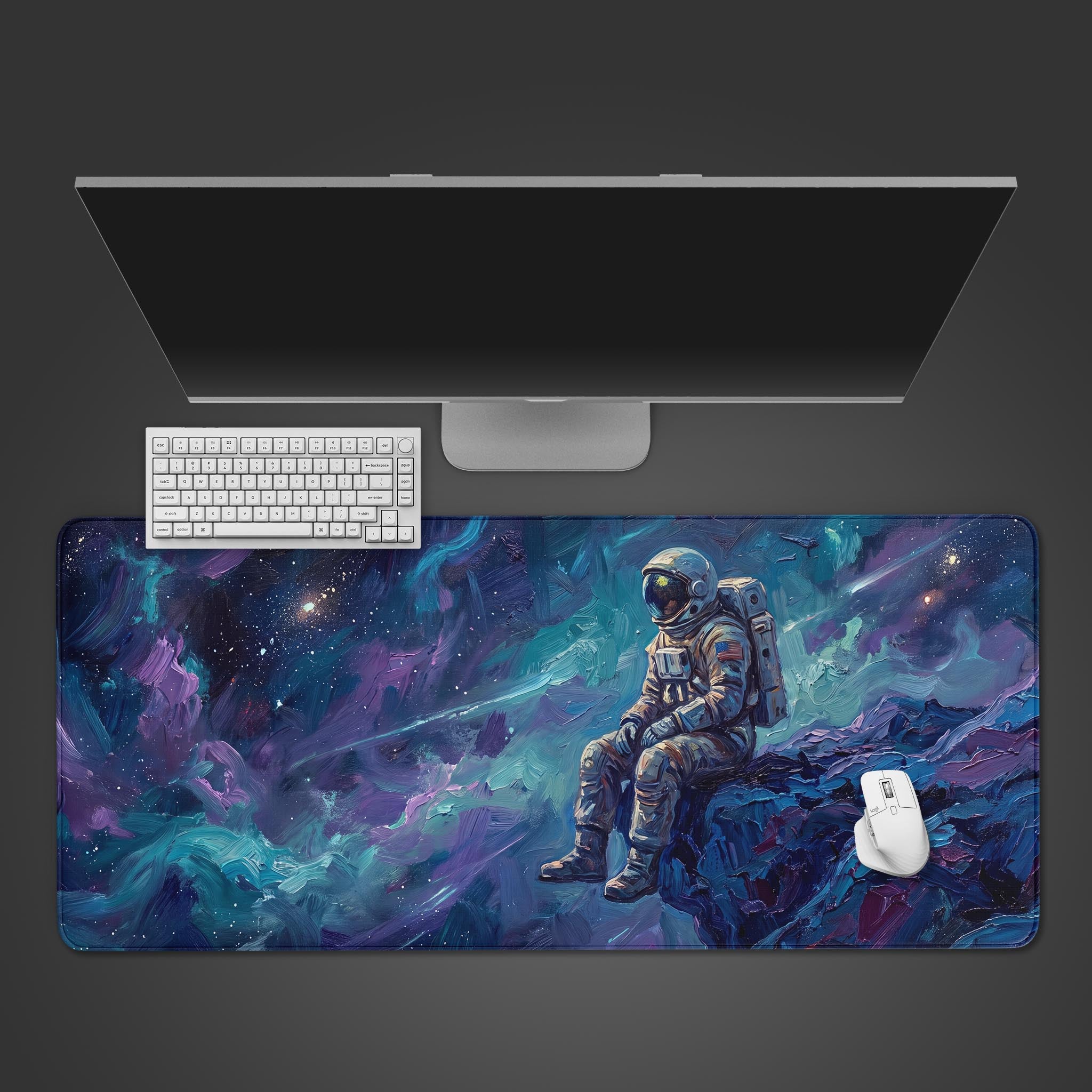 A wide desk mat featuring an astronaut sitting on a rocky cliff, painted in thick blue and purple impasto strokes.