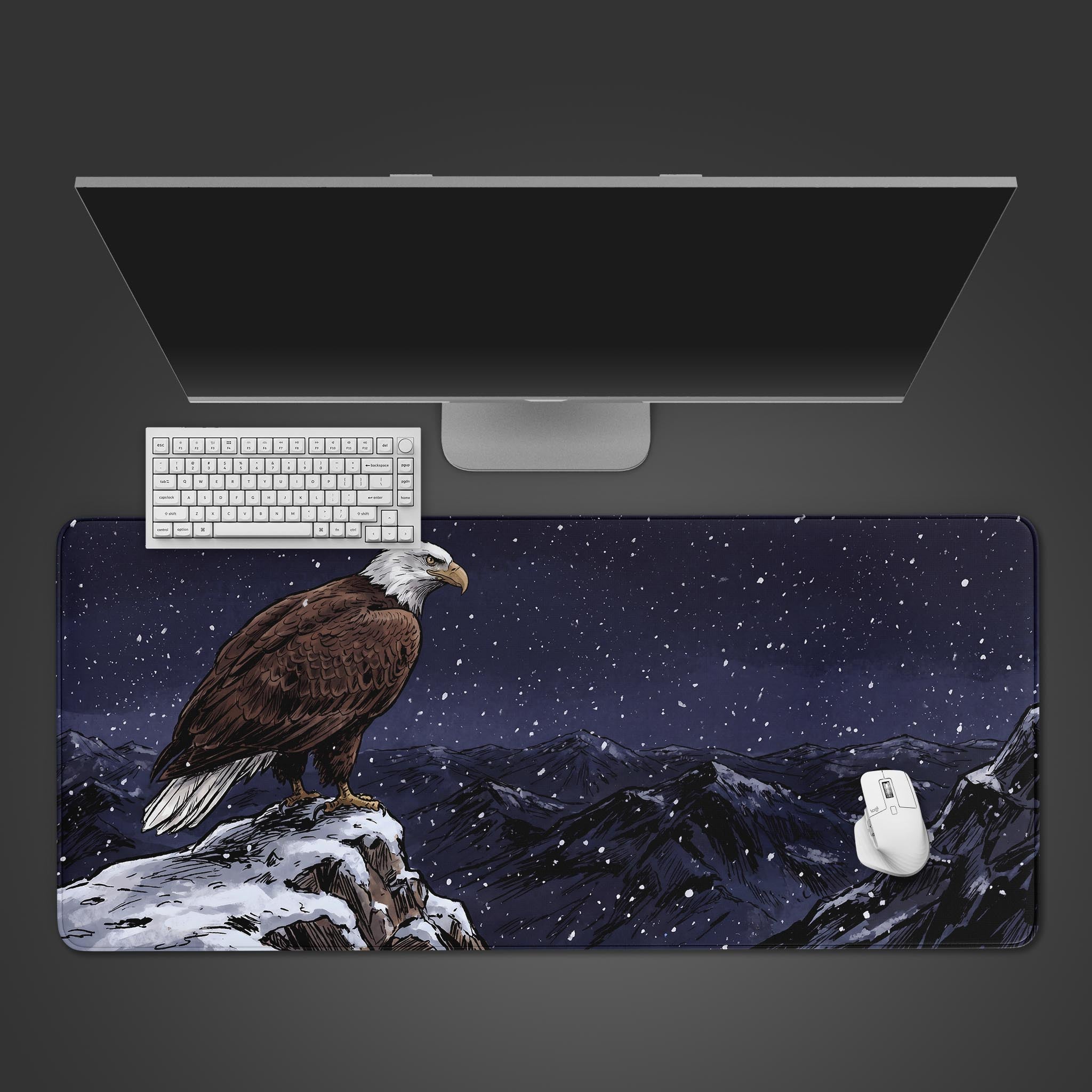 Large desk mat featuring a detailed illustration of a bald eagle perched on a snowy mountain peak at night.