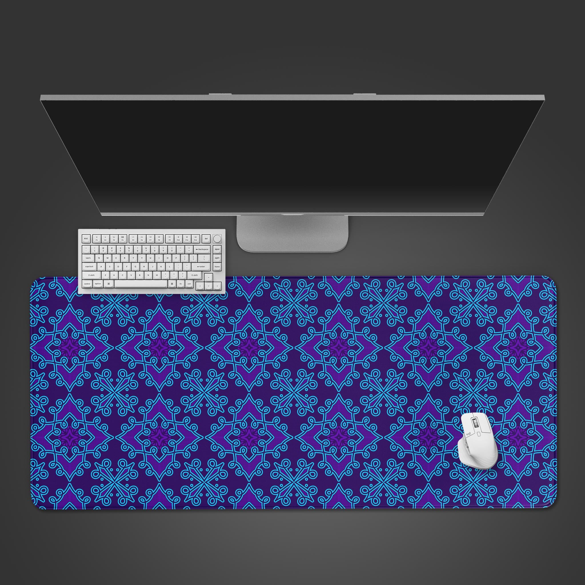 Batik pattern desk mat with electric blue and purple swirls. Top-down view on a desk with a keyboard and mouse, showing the vibrant, intricate design. - Epic Design Pads & Mousepads