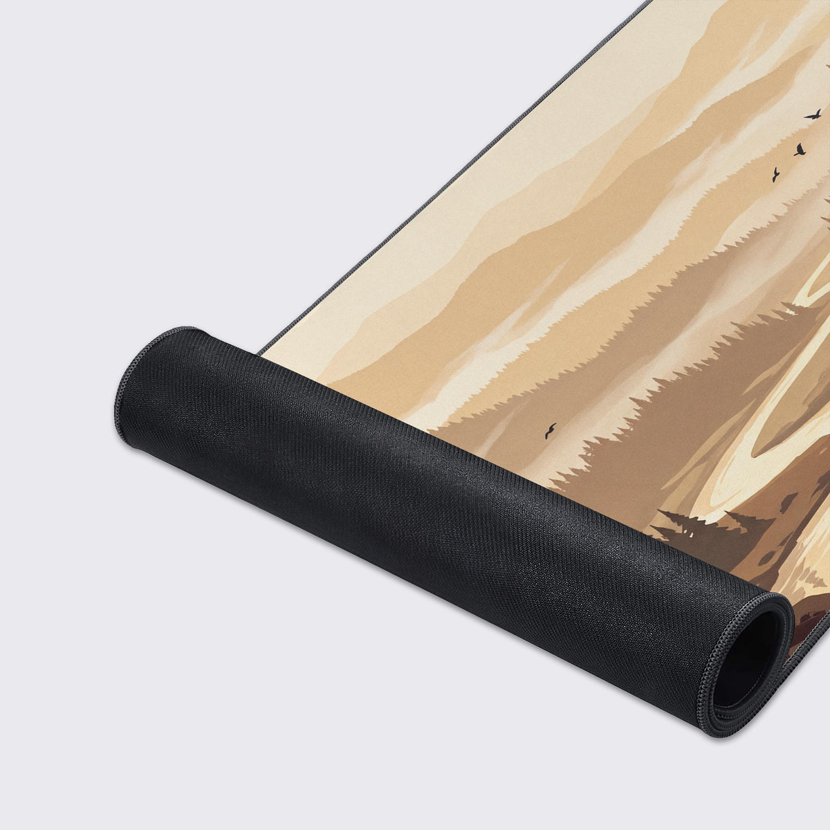 Beige and brown forest valley desk mat partly rolled up, showing its black non-slip rubber underside