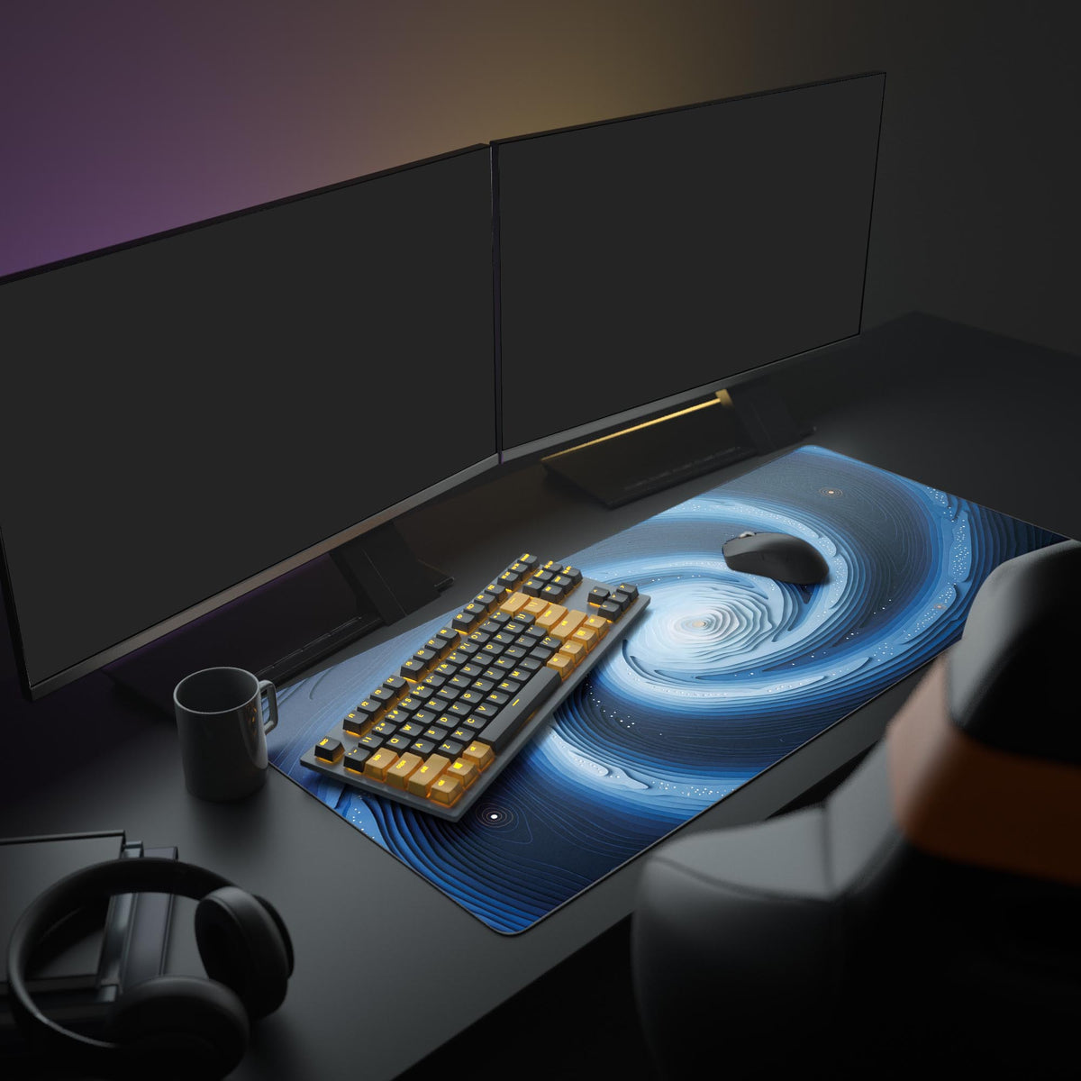Layered blue spiral desk mat on a dark desk in a room with two monitors, orange-key keyboard, mouse, mug and headphones