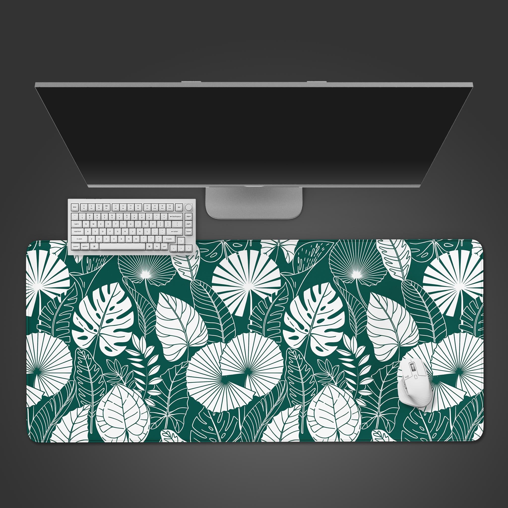 Botanical Teal desk mat with tropical leaf pattern, shown from a top-down view on a desk with a white keyboard and mouse. - Epic Design Pads