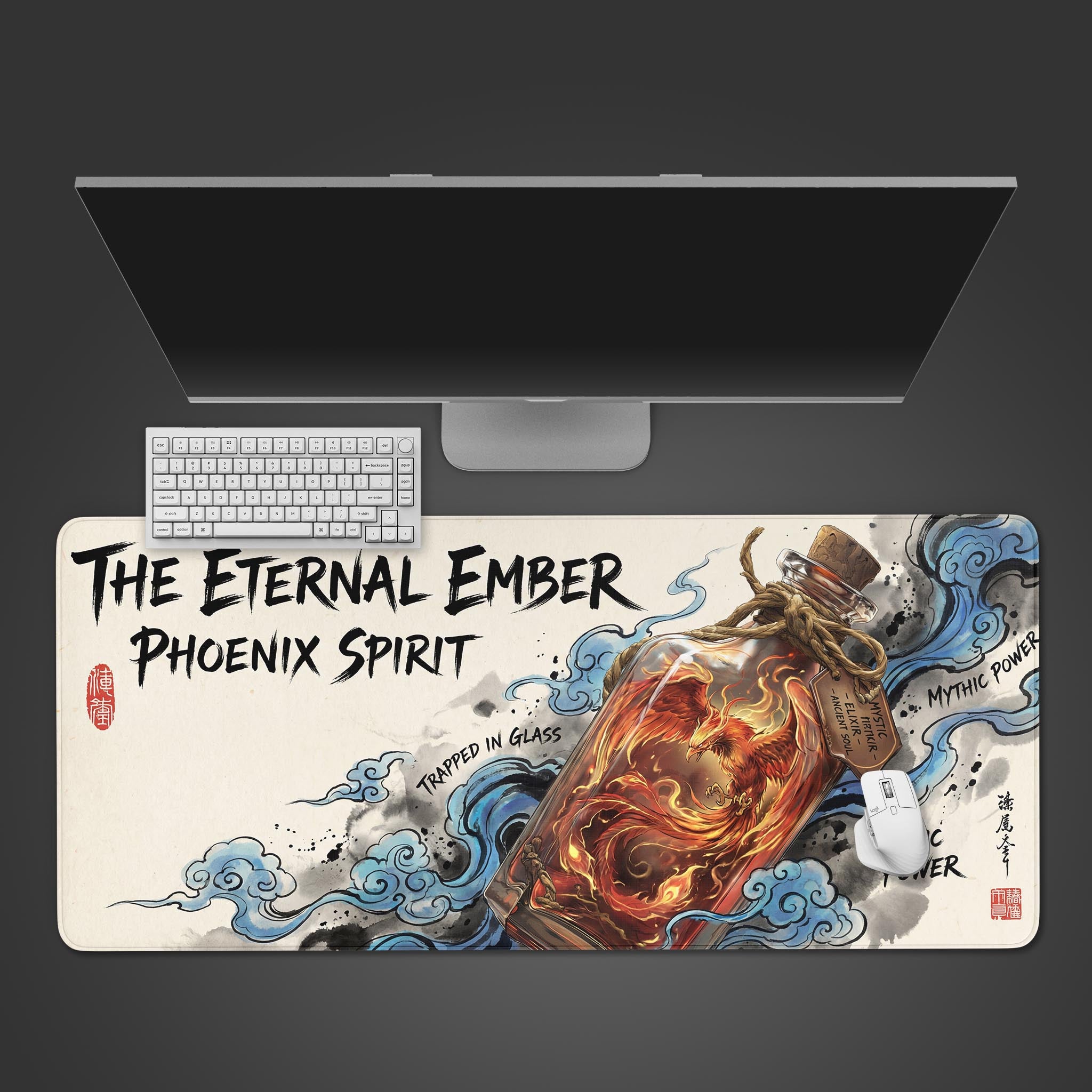 Top-down view of the Bottled Phoenix gaming desk mat on a desk with a white keyboard, mouse, and monitor, showcasing the vibrant mythical design. - Epic Design Pads & Mousepads