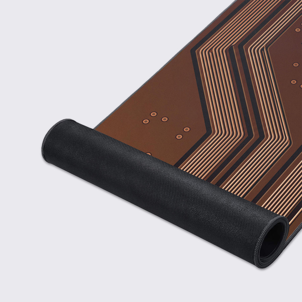 Brown mat with cream and copper circuit traces and round vias, partly rolled up to show its black rubber underside