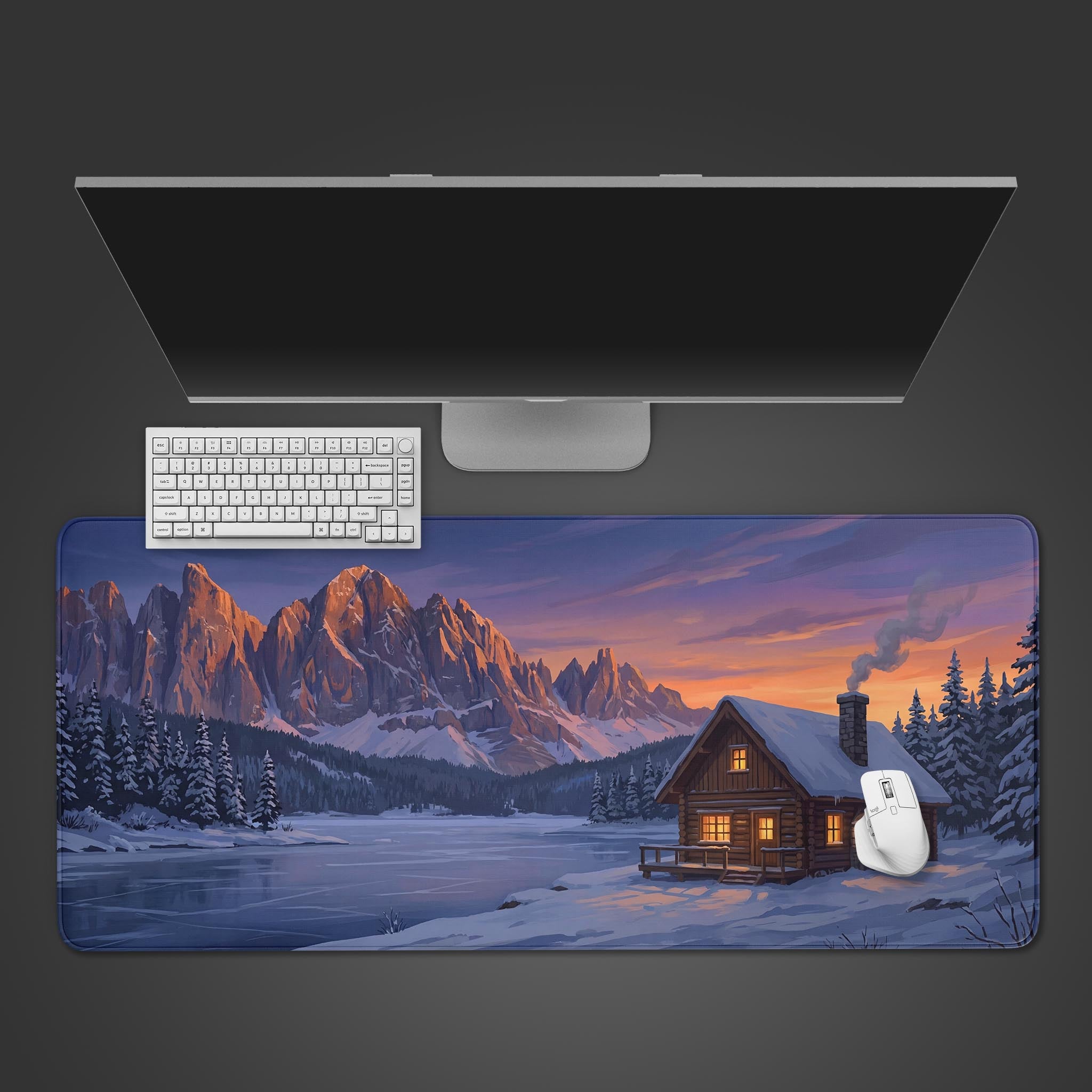 Top-down view of the Cabin Retreat gaming desk mat, featuring a snowy mountain landscape, with a white keyboard and mouse on top. - Epic Design Pads & Mousepads