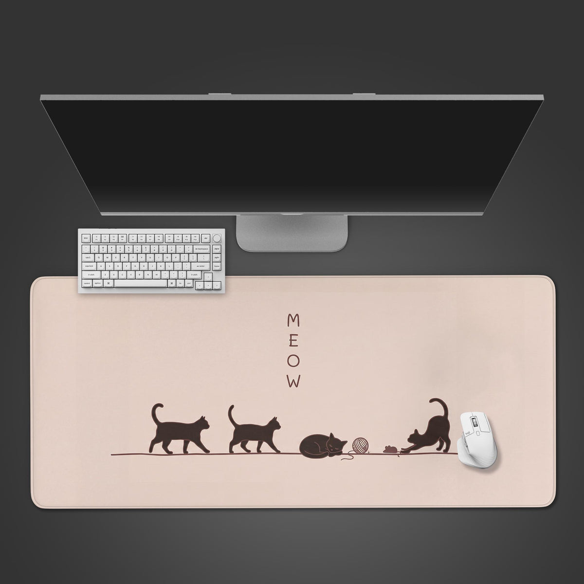A cream-colored desk mat featuring minimalist dark brown silhouettes of four cats and the word MEOW.