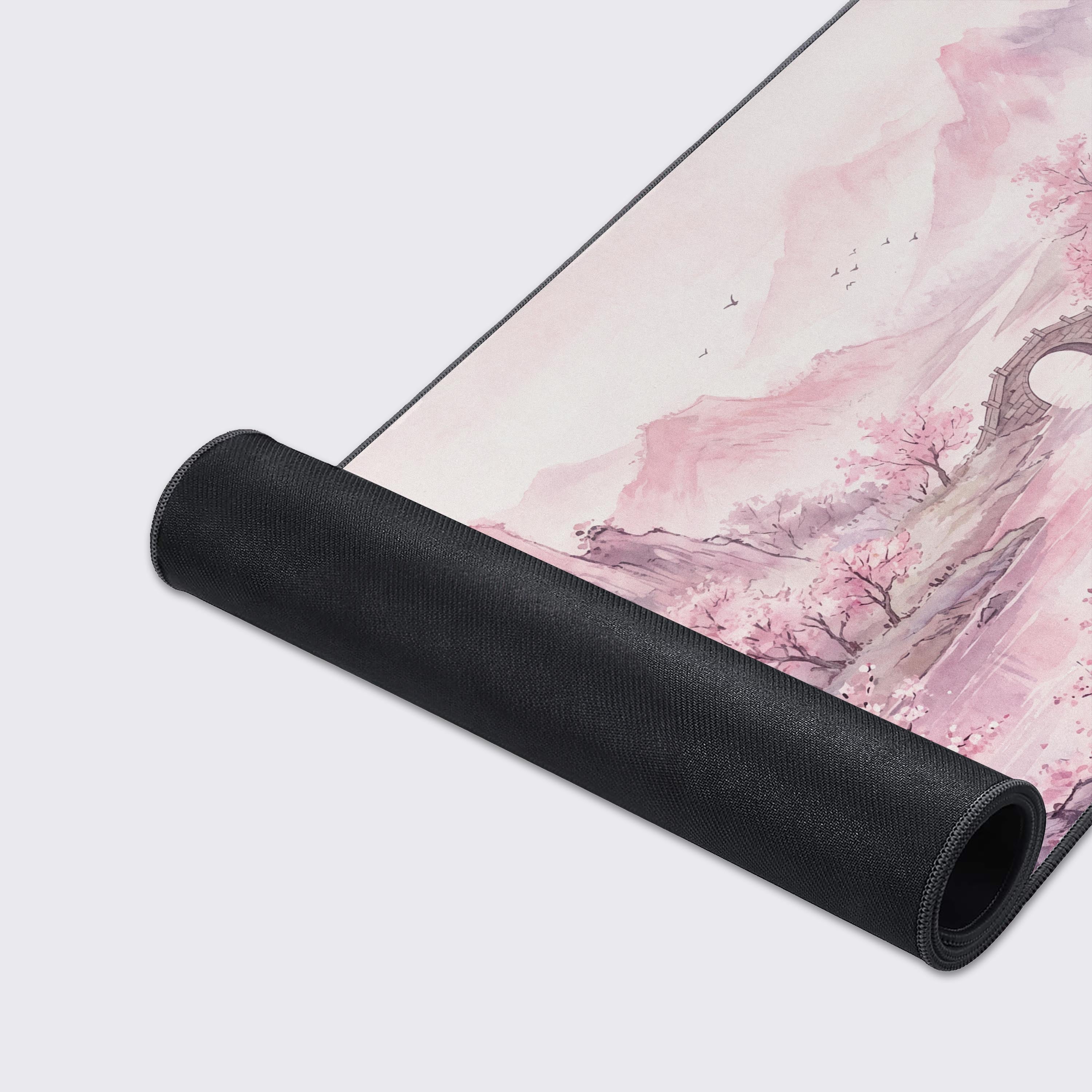 Detailed view of the traditional ink wash style mountains and stone bridge on the desk mat.