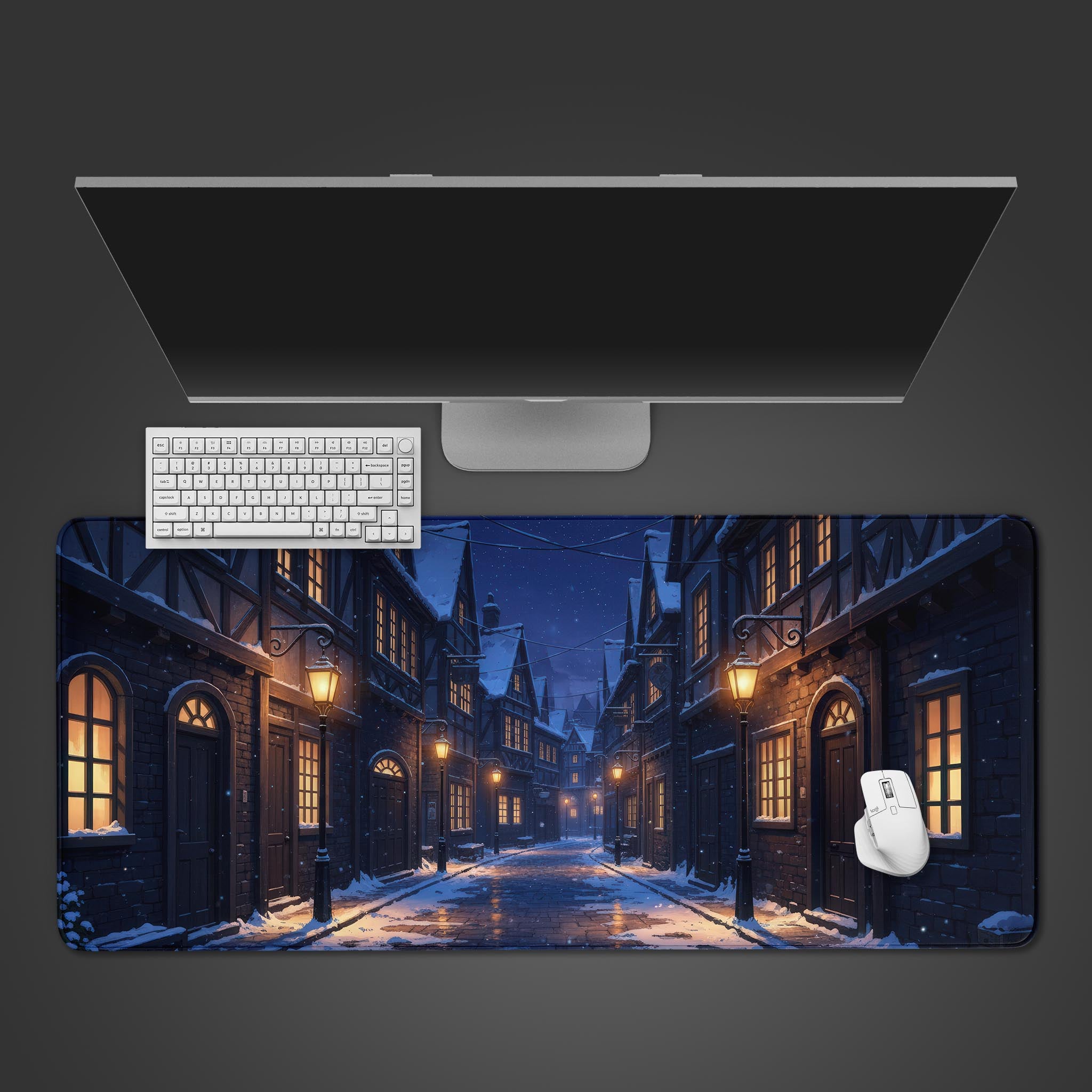 Cobblestone Winter desk mat showing a snowy European street scene at night – top-down desktop view with a white keyboard and mouse. - Epic Design Pads