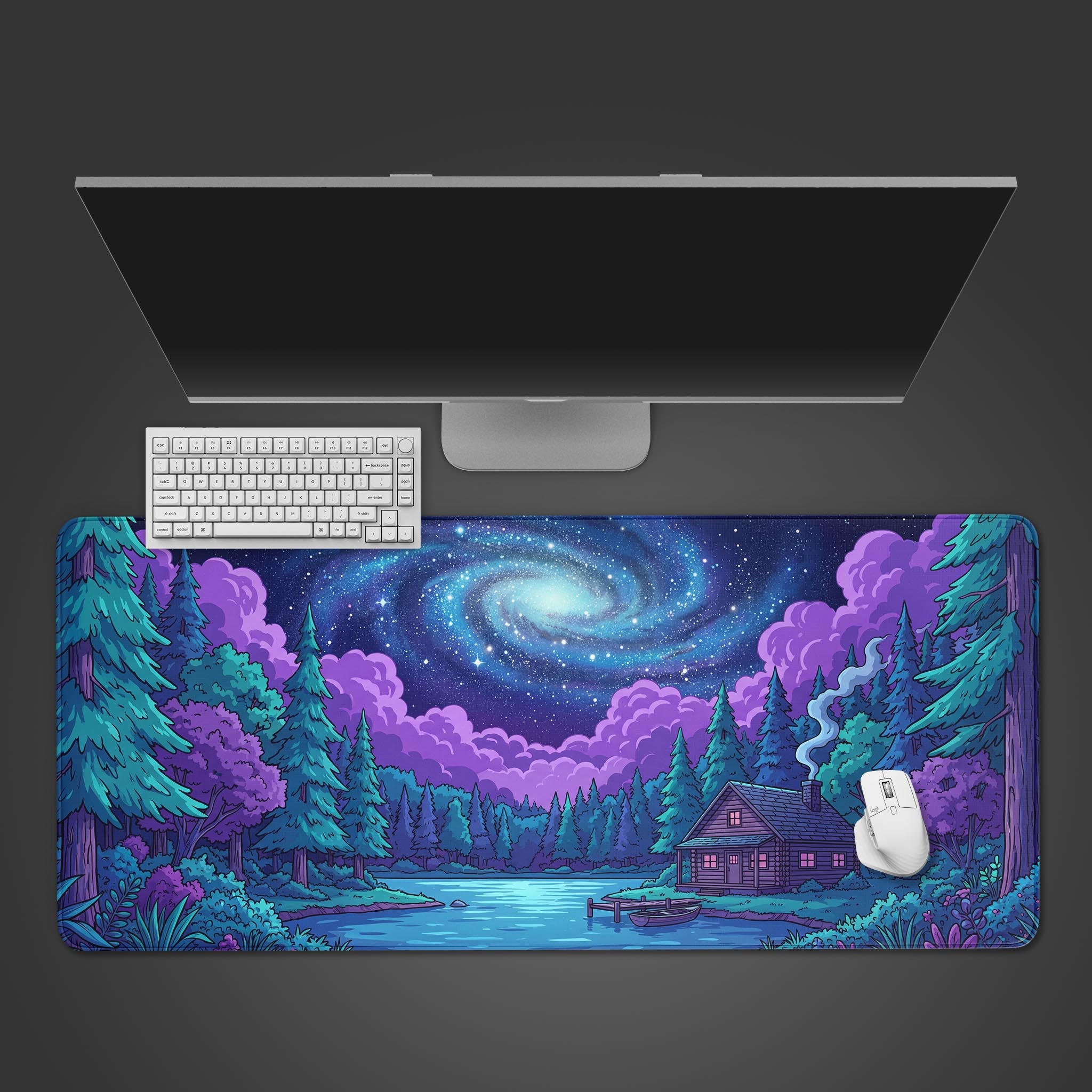A top-down view of the Cosmic Cabin gaming desk mat, showing the galaxy and forest design beneath a clean white keyboard and mouse on a dark surface. - Epic Design Pads & Mousepads