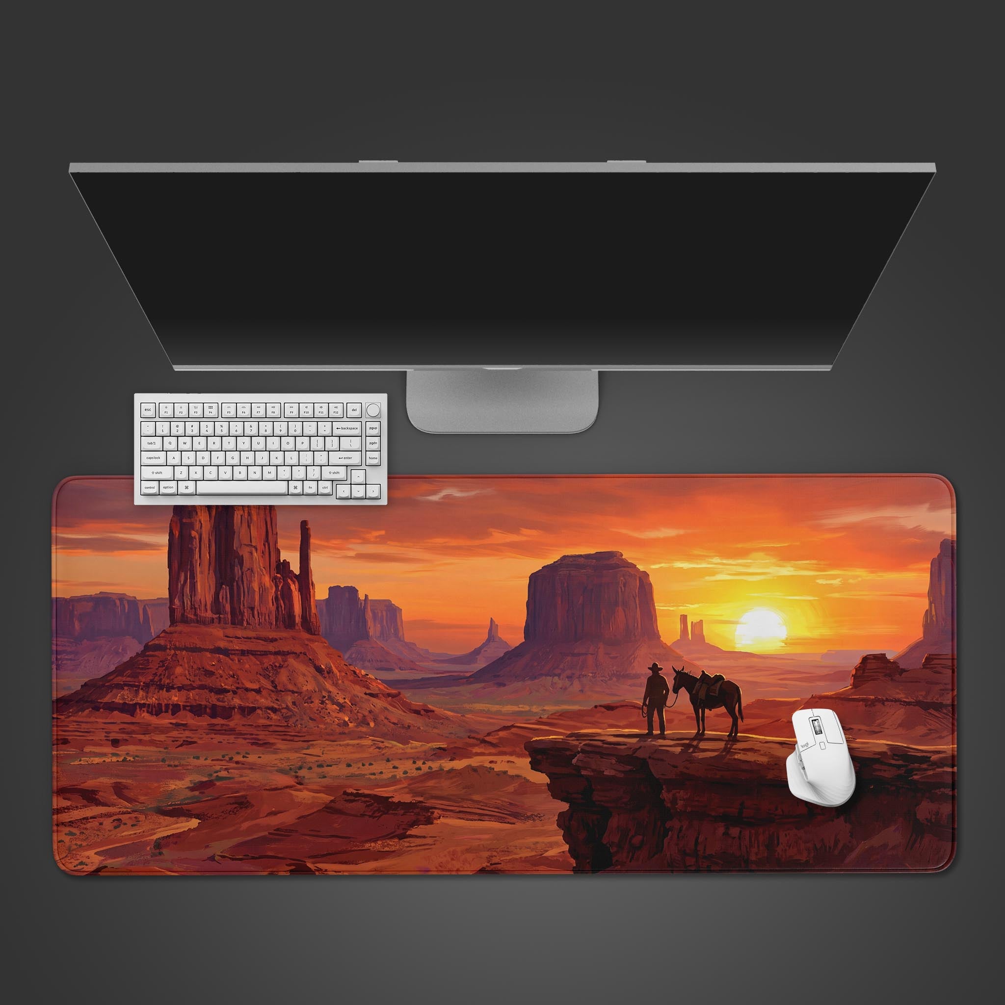 A desk mat displaying a western desert landscape at sunset with a cowboy and horse.