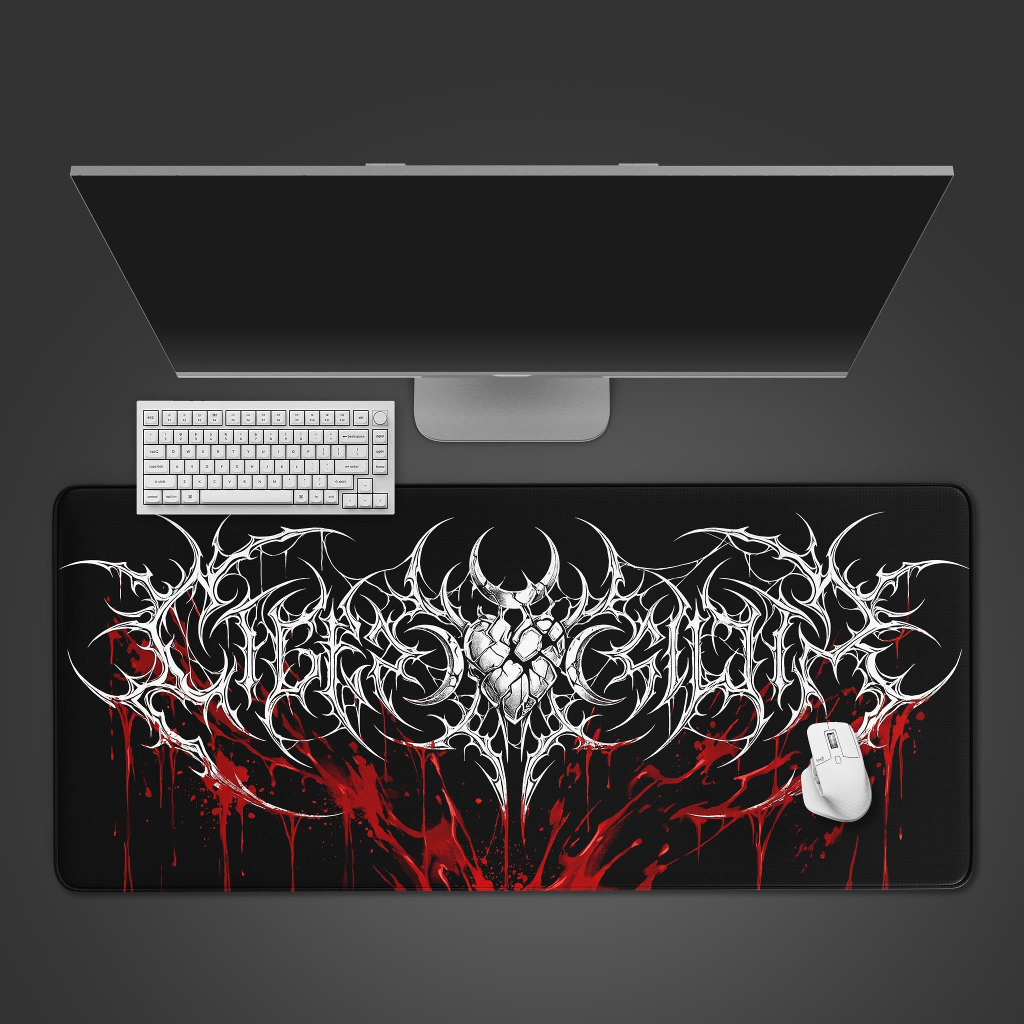 A top-down view of the Crimson Sigil gaming desk mat, showing its cybersigilism design with a white keyboard, mouse, and a large monitor on a dark surface. - Epic Design Pads & Mousepads