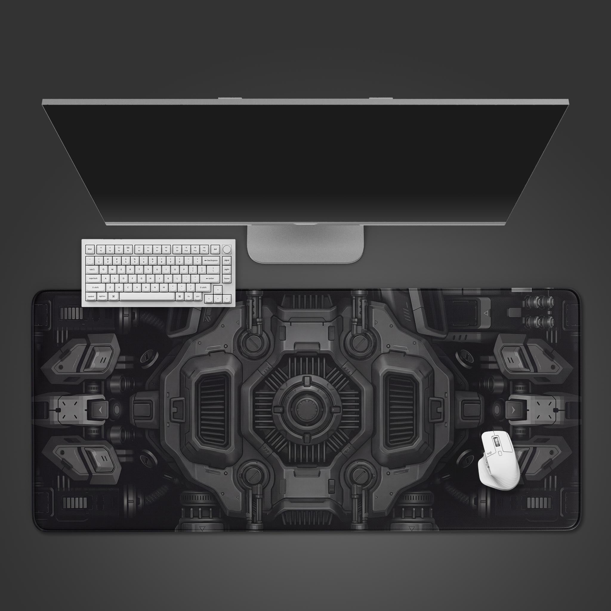Top-down view of the Dark Engine gaming desk mat, showcasing its monochrome mechanical design beneath a white keyboard, mouse, and a large monitor. - Epic Design Pads & Mousepads