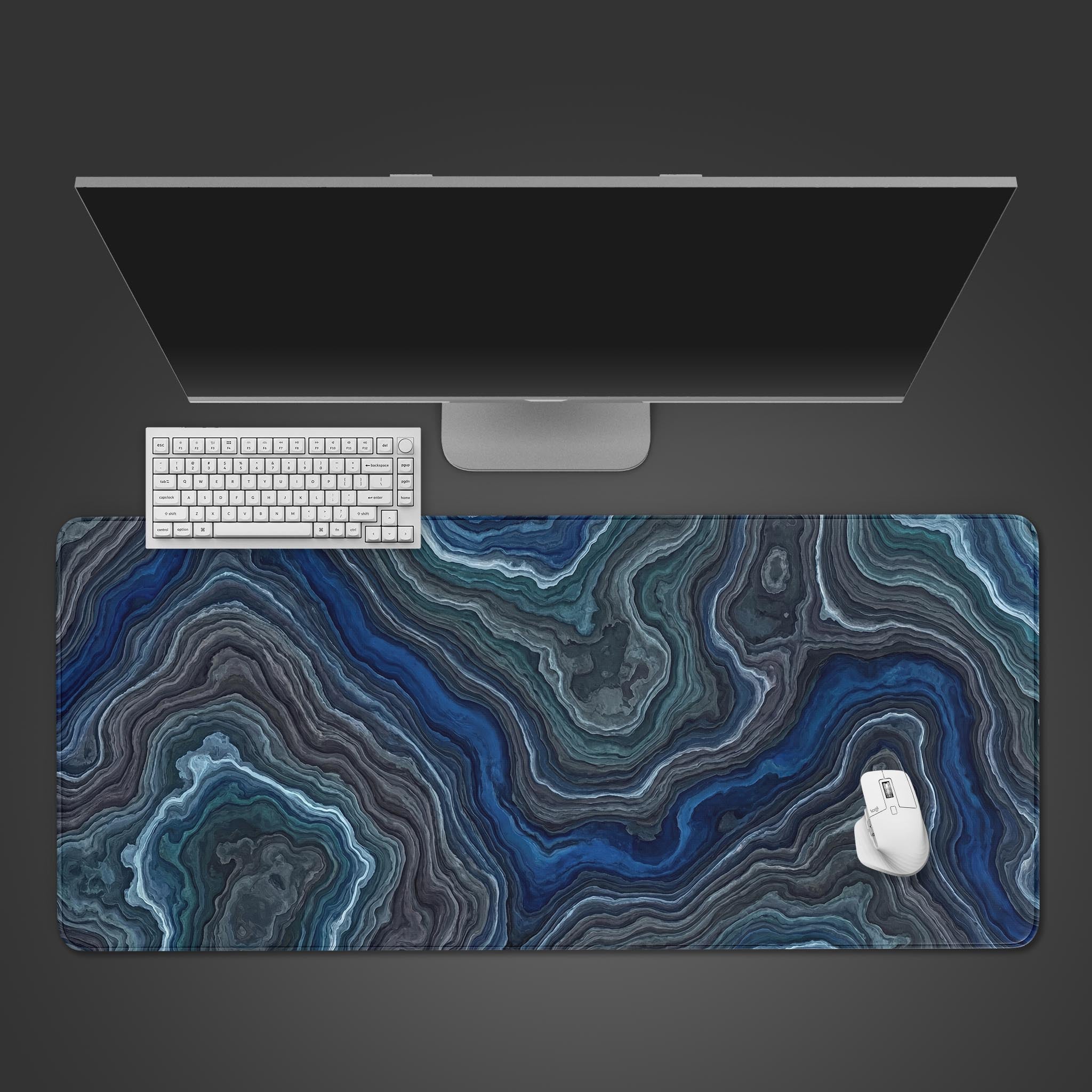 Top-down view of the Deep Strata gaming desk mat, featuring a blue and gray agate pattern, shown with a white keyboard and mouse on a dark background. - Epic Design Pads & Mousepads
