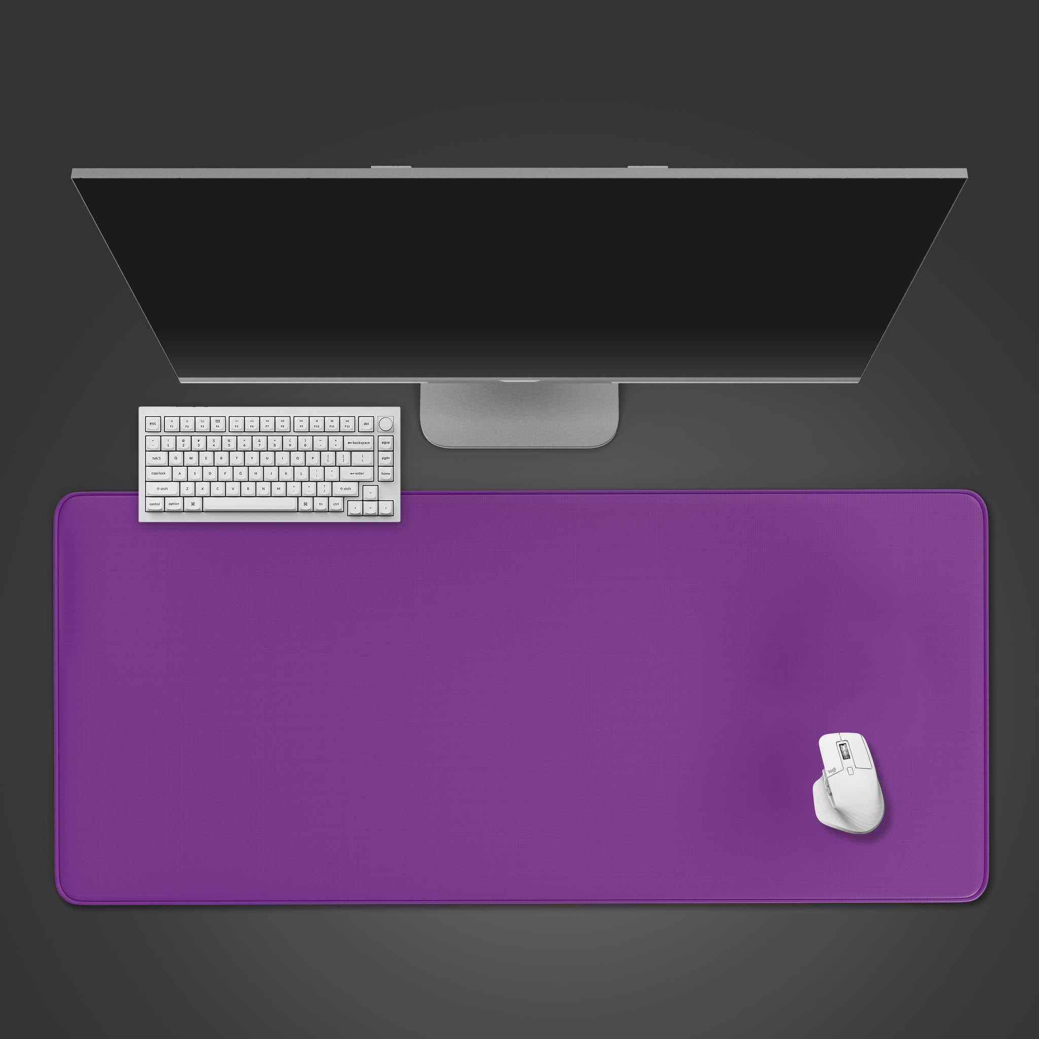Top-down view of the Deep Violet gaming desk mat with a white keyboard and mouse, placed below a sleek monitor on a dark background. - Epic Design Pads & Mousepads