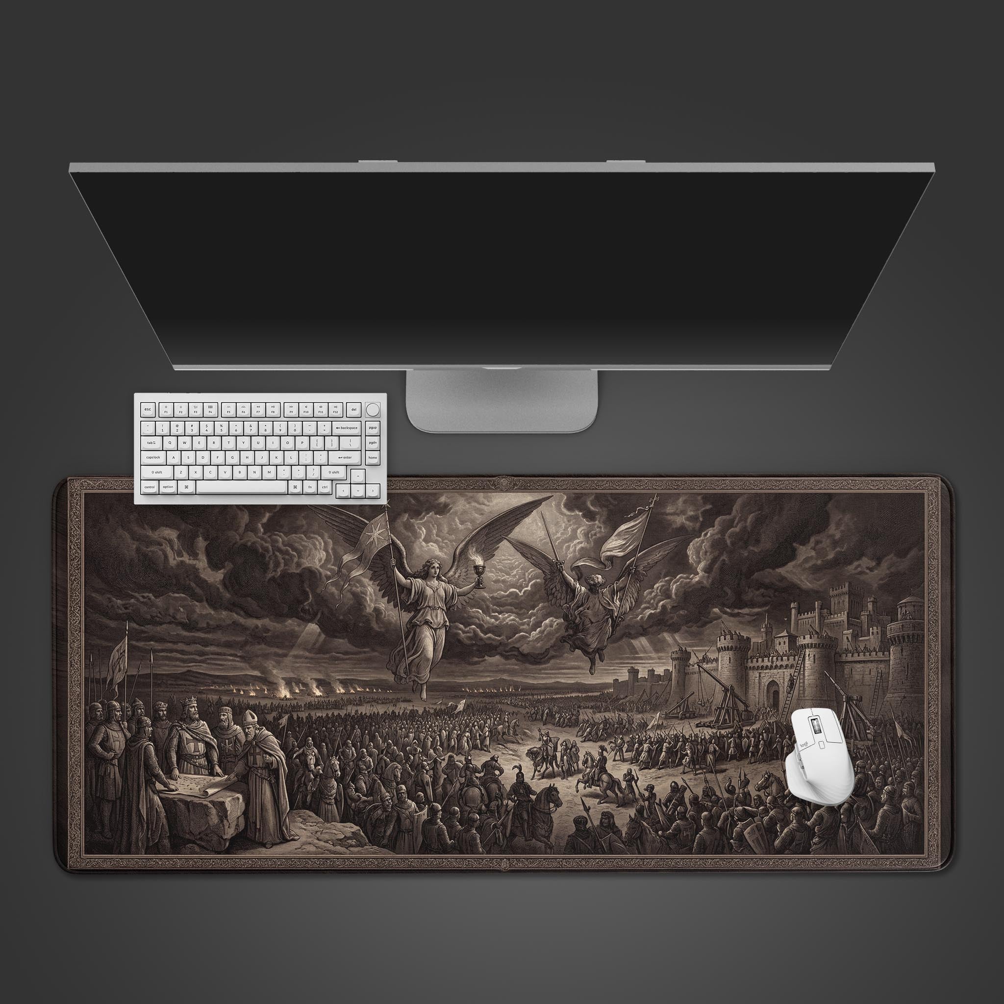 Top-down view of the Divine Siege gaming desk mat, featuring a classical battle scene. A white keyboard and mouse are positioned on the large, monochrome surface below a monitor. - Epic Design Pads & Mousepads