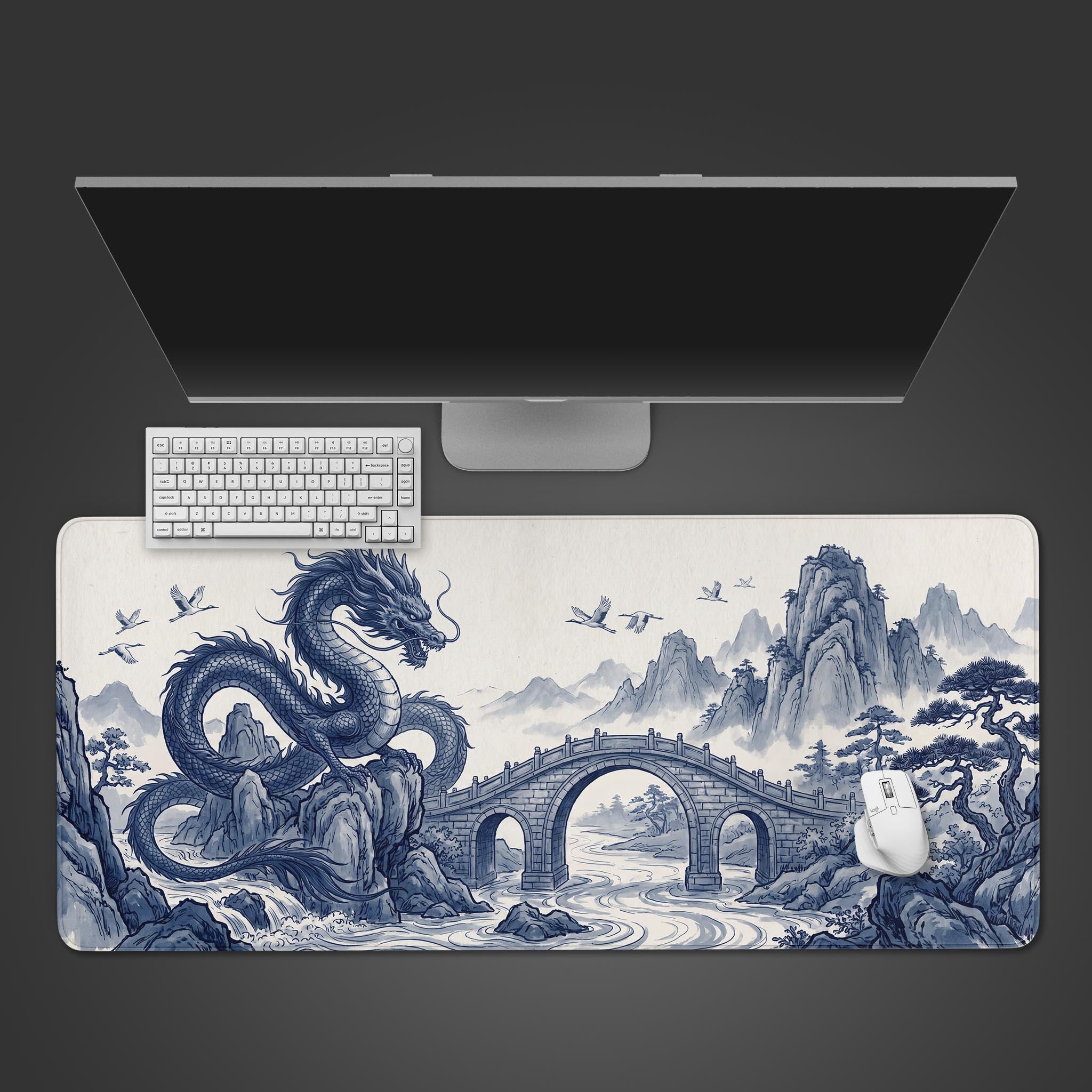 A large rectangular desk mat featuring a traditional Chinese blue and white ink wash painting of a majestic dragon resting by a stone bridge and mountains.