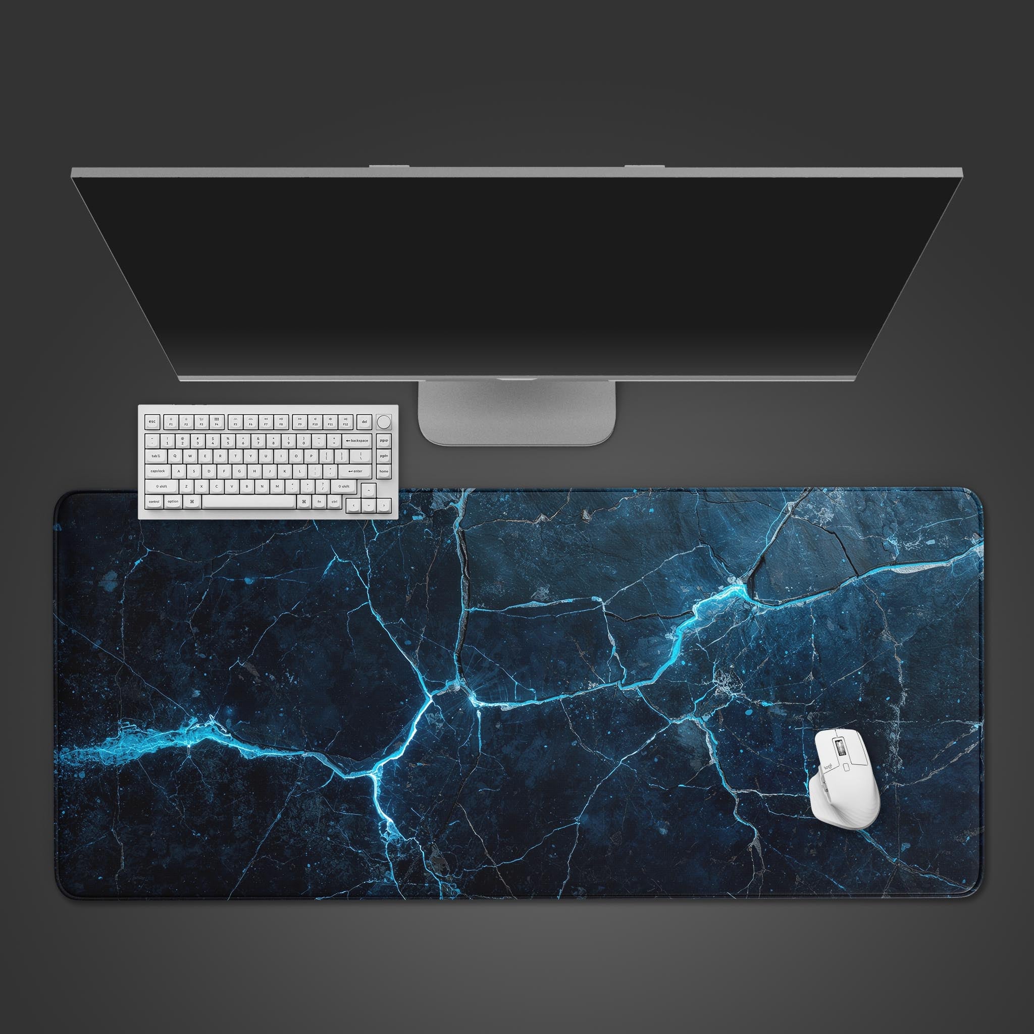 Top-down view of the Electric Veins gaming desk mat with a black keyboard and mouse, showcasing the abstract blue cracked earth design on a clean desk. - Epic Design Pads & Mousepads