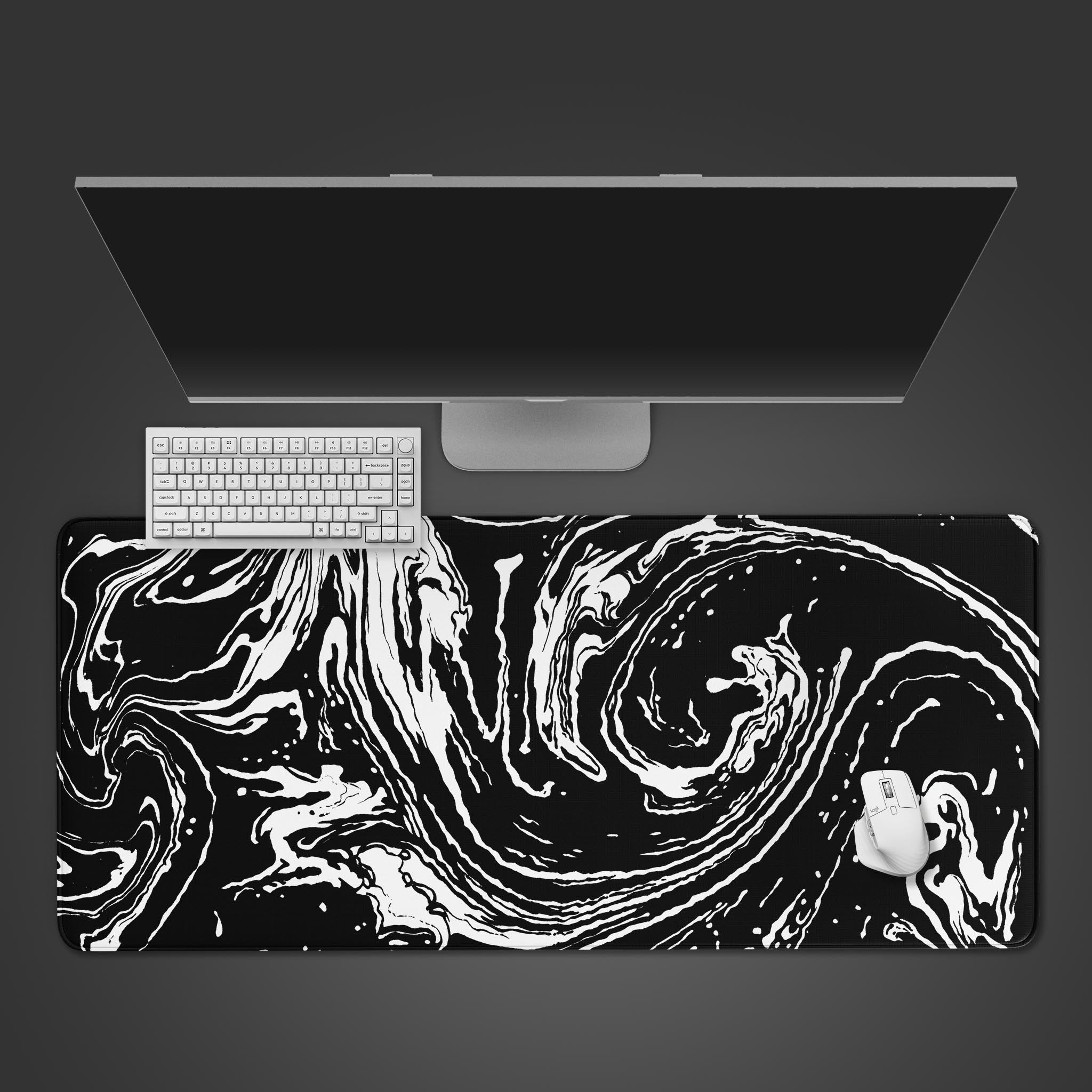 A black and white abstract fluid art desk mat with swirling liquid patterns.
