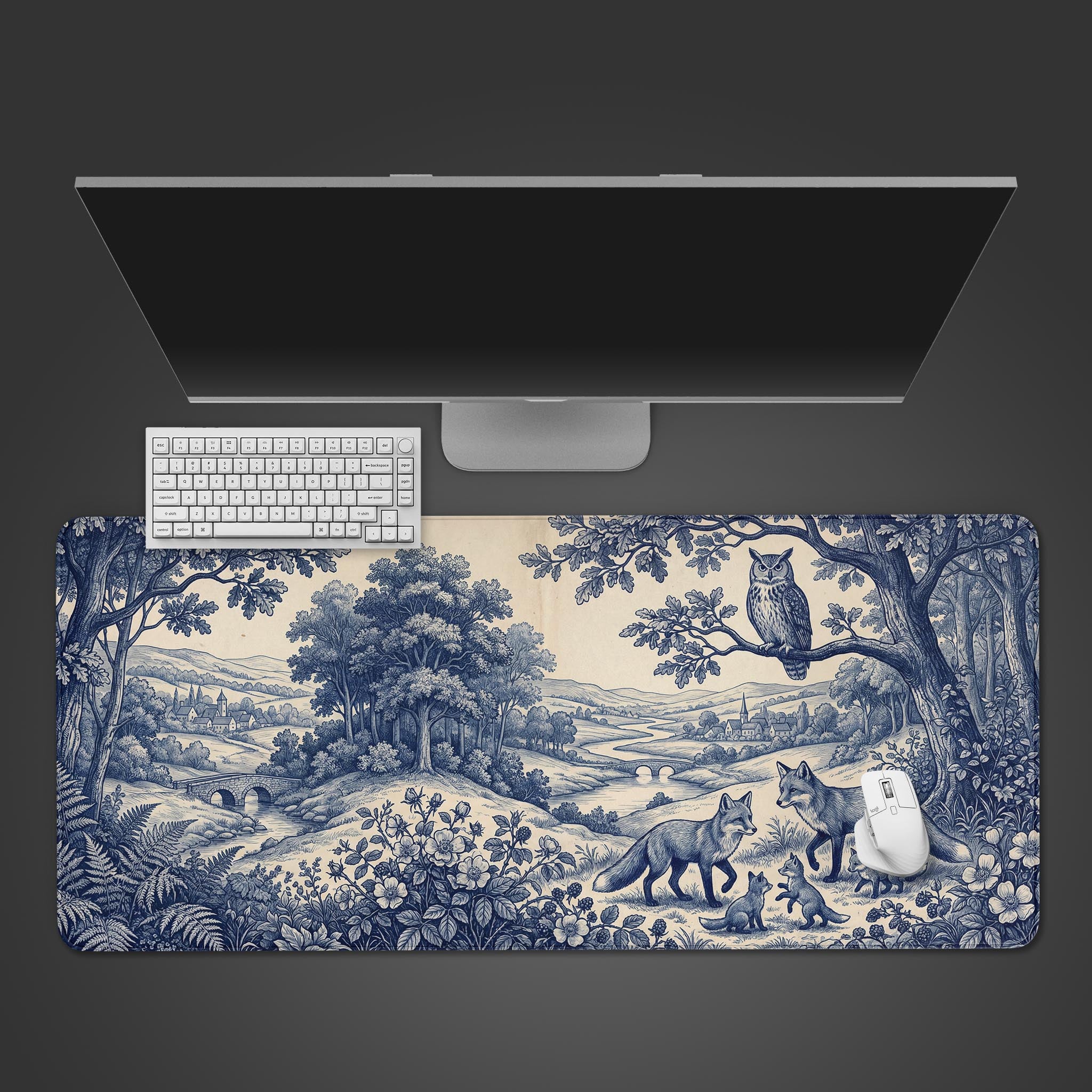 Top-down view of the Foxwood Toile gaming desk mat, featuring a vintage blue and white forest scene with a keyboard and mouse. - Epic Design Pads & Mousepads