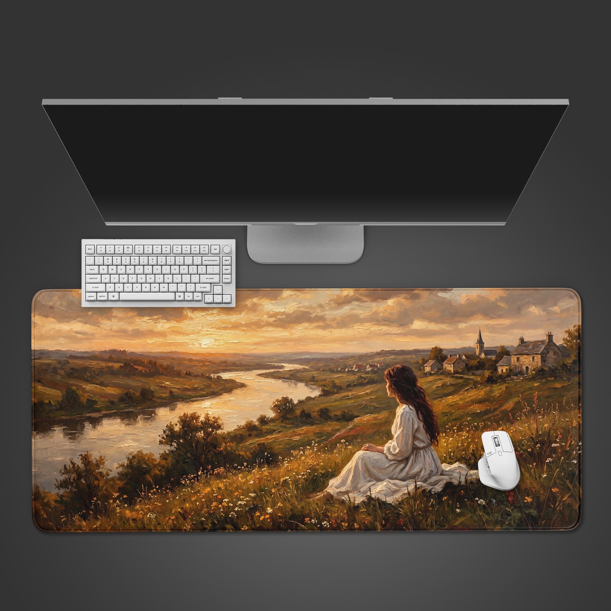 Golden valley pastoral sunset fine art desk mat showcasing a woman sitting in a meadow overlooking a river and village