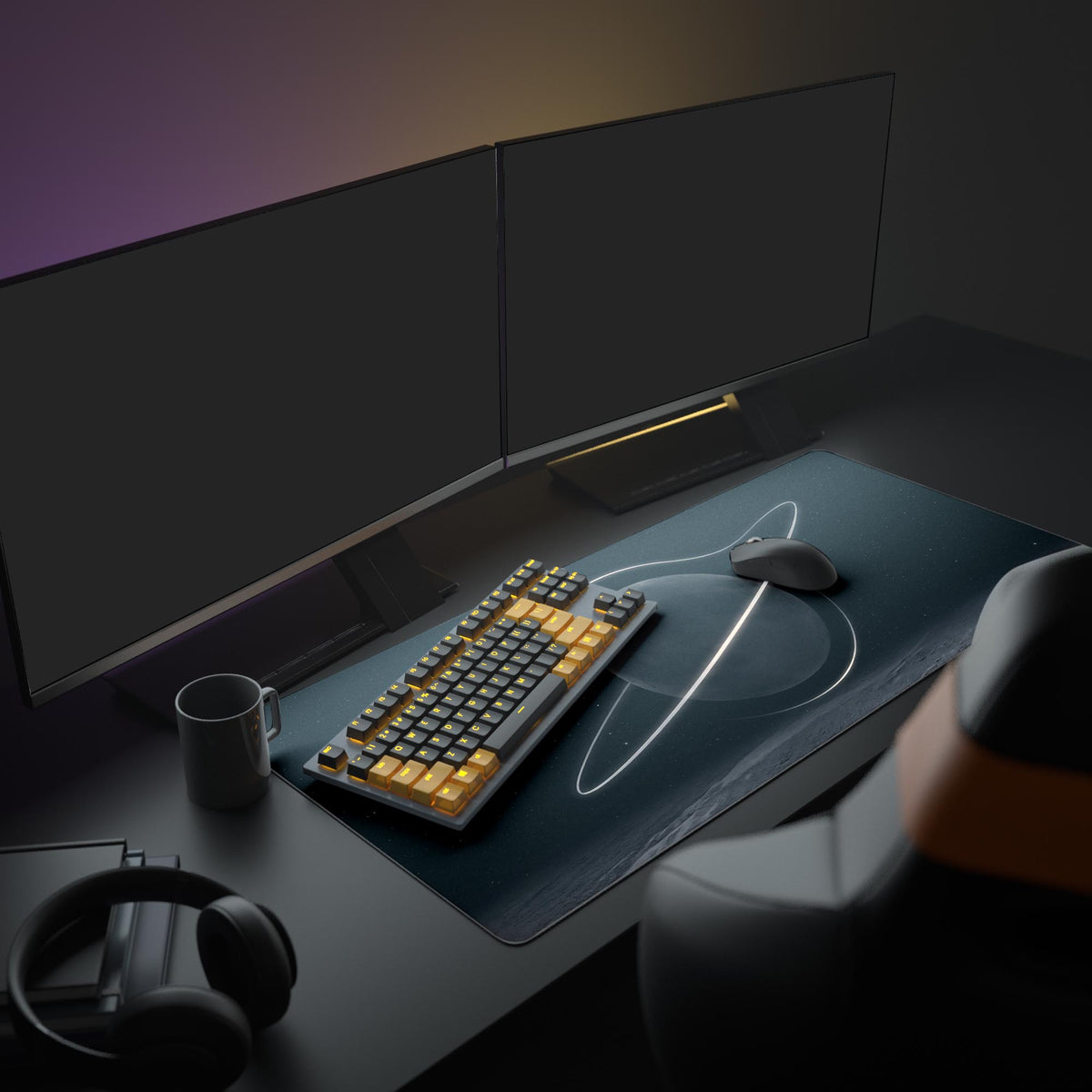 Ringed dark moon desk mat on a desk in a dim room with two monitors, an orange-keyed keyboard, mouse, mug and headphones