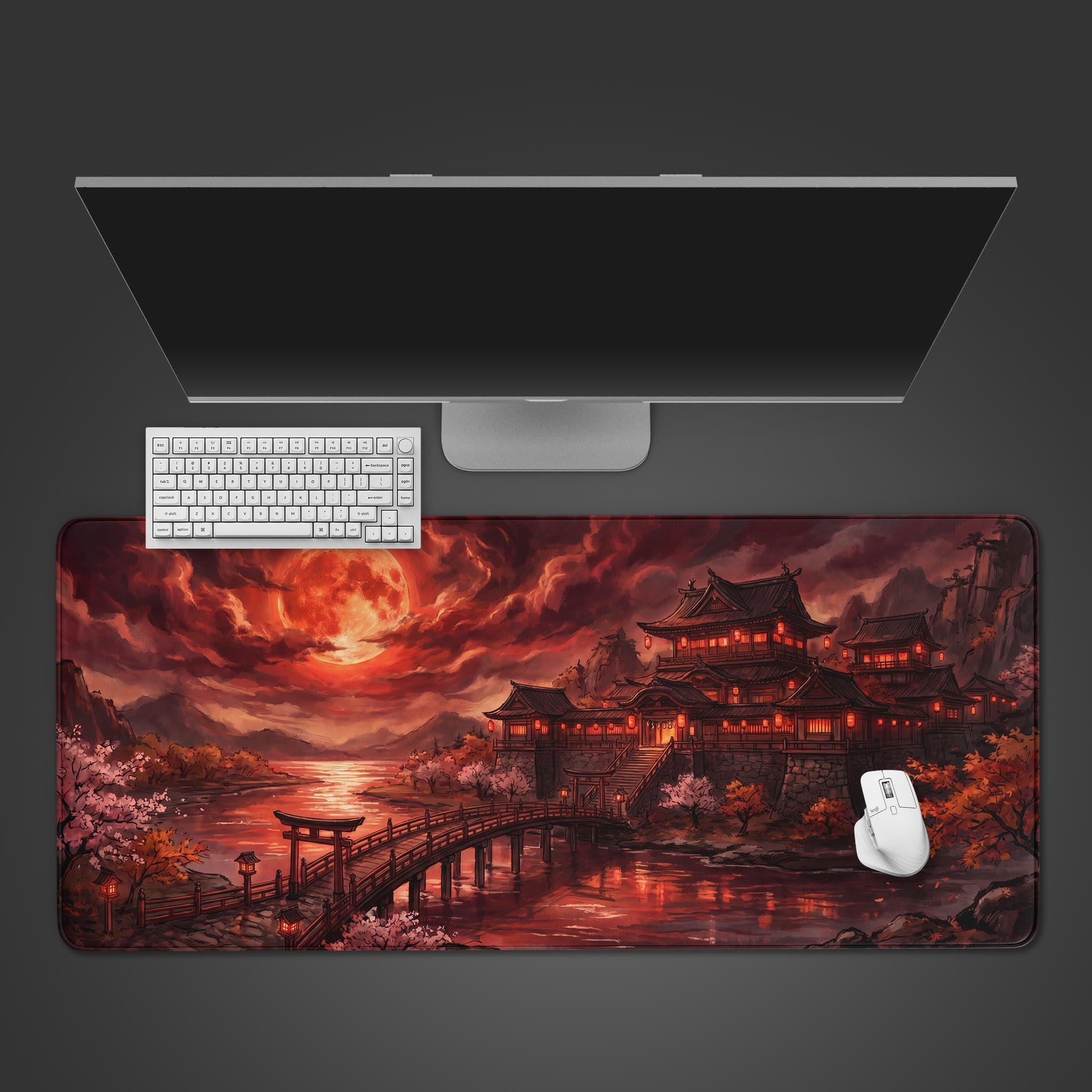A large gaming desk mat featuring a dark fantasy Japanese castle under a giant red blood moon, with a torii gate and bridge over water.