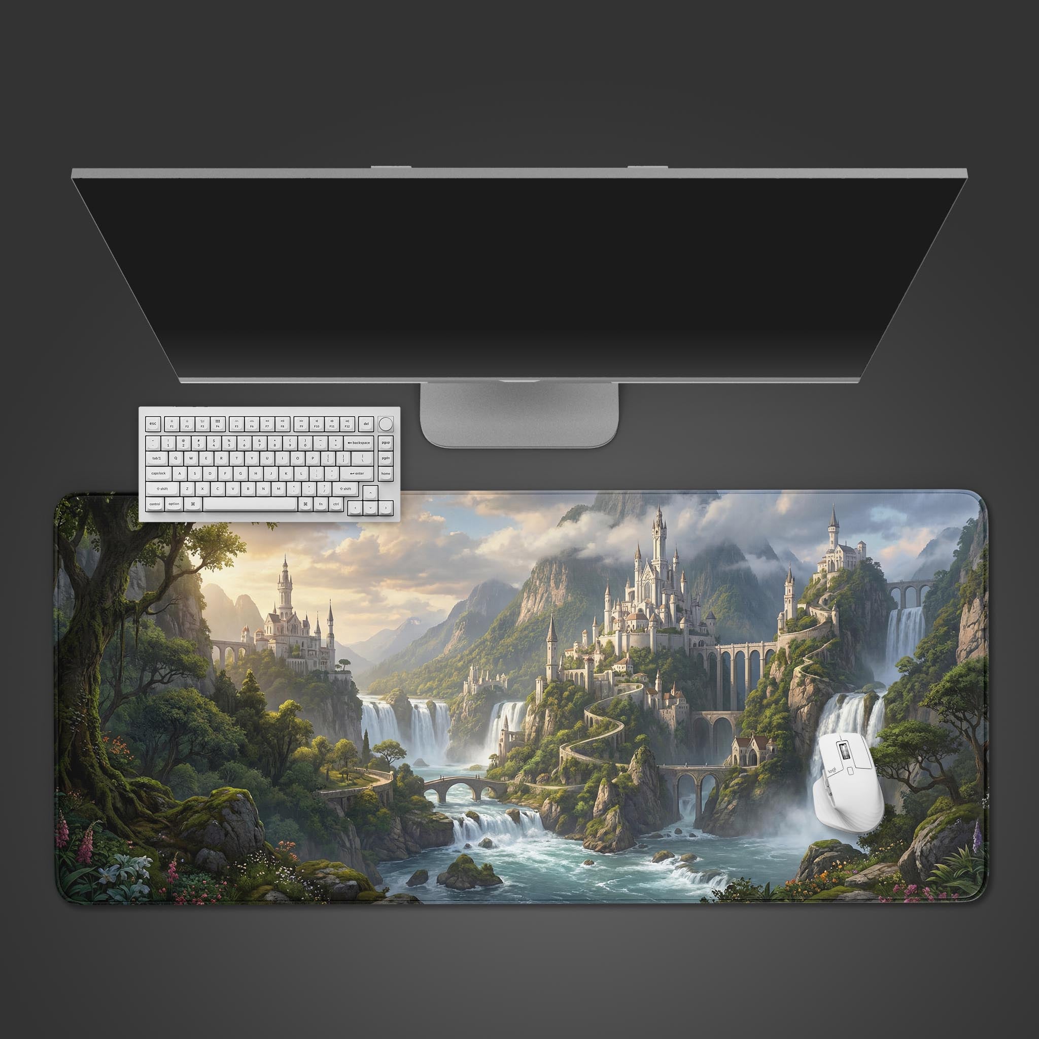 Top-down view of the Kingdom of Falls gaming desk mat, showcasing its epic fantasy castle design beneath a sleek monitor, white keyboard, and mouse. - Epic Design Pads & Mousepads