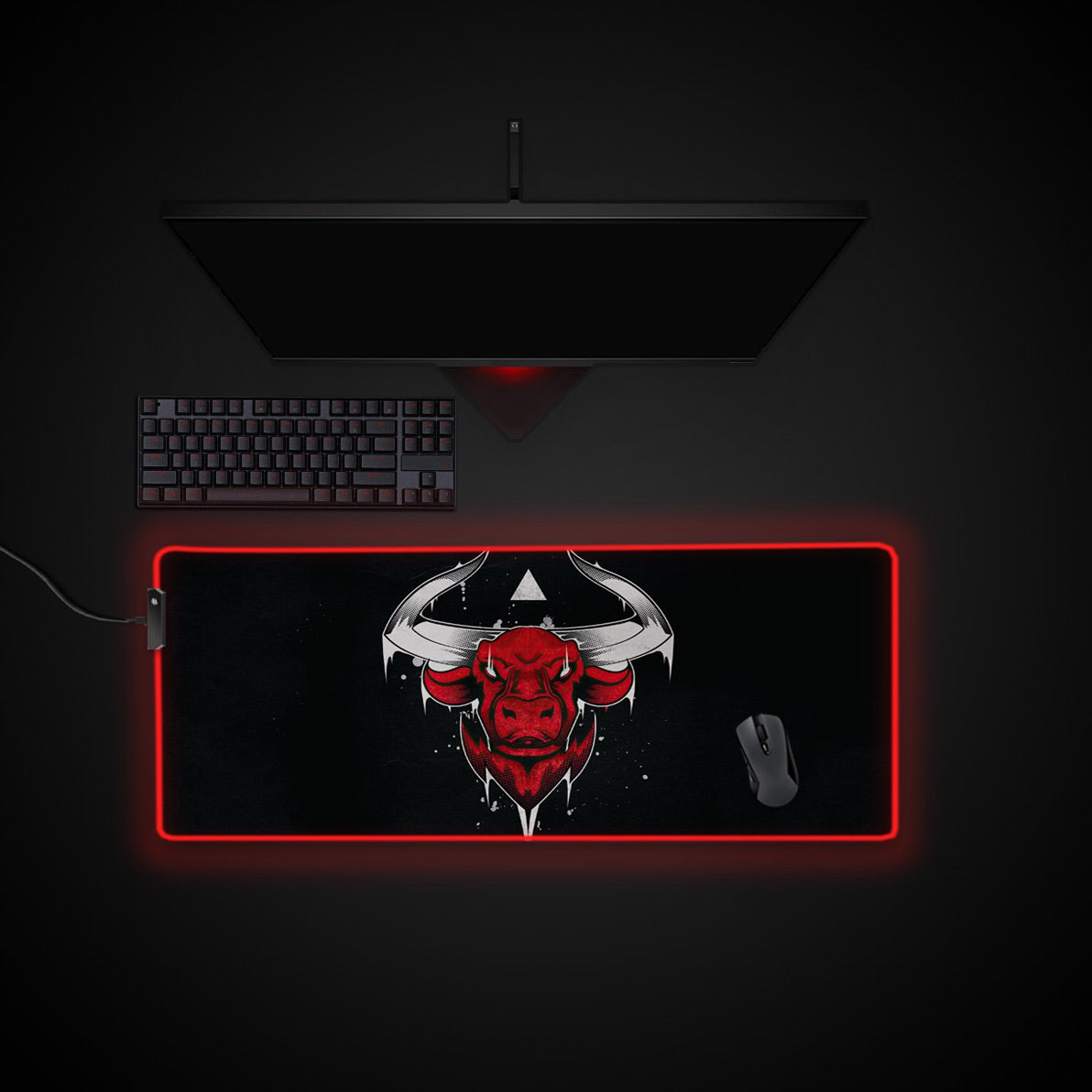 Gaming setup with a large mouse pad featuring a bull design on a dark background