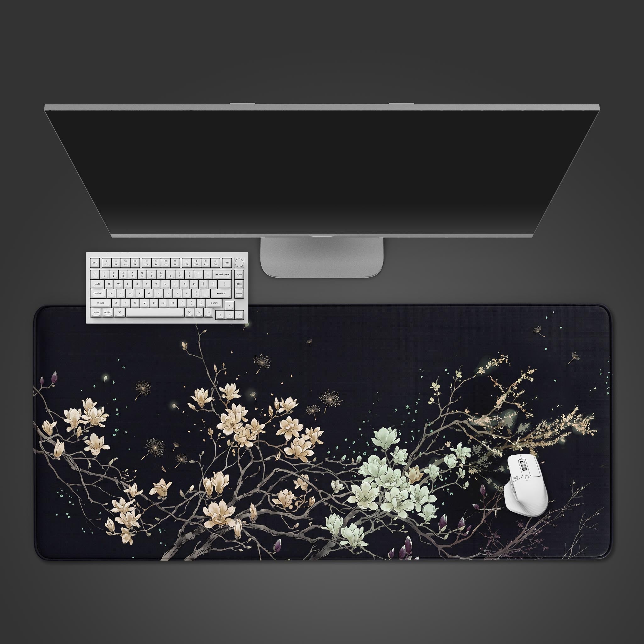 Midnight Magnolia dark floral desk mat showcasing pale flowers on a black background