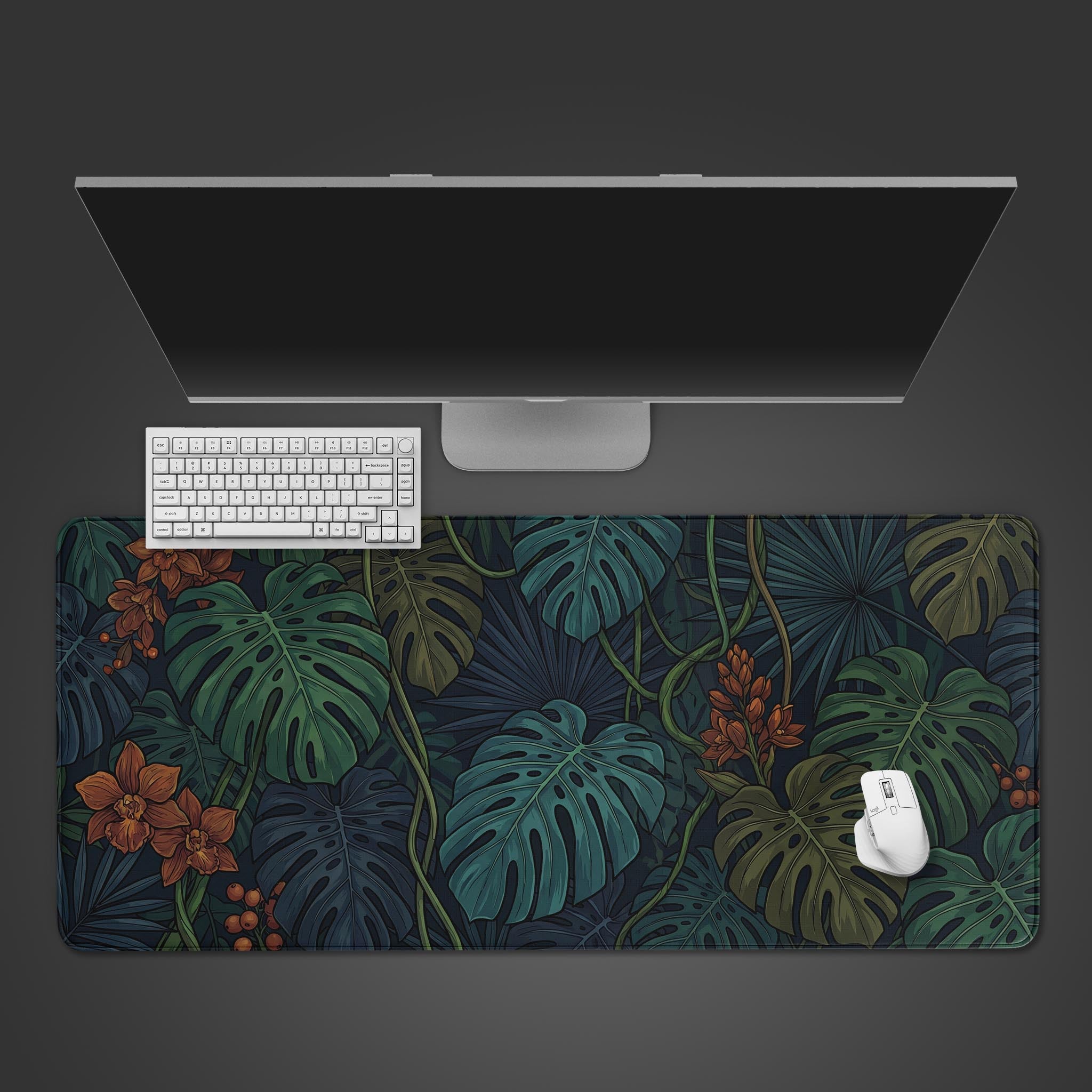 Top-down view of the Midnight Jungle gaming desk mat featuring a dark botanical leaf pattern, shown with a white keyboard and mouse on a grey desk. - Epic Design Pads & Mousepads