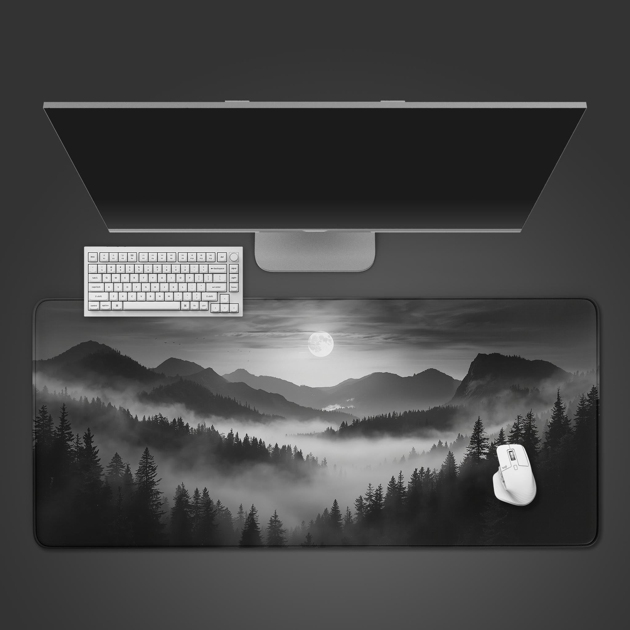 Misty Mountains desk mat with monochrome landscape design, shown on a desk with a keyboard and mouse from a top-down view. - Epic Design Pads