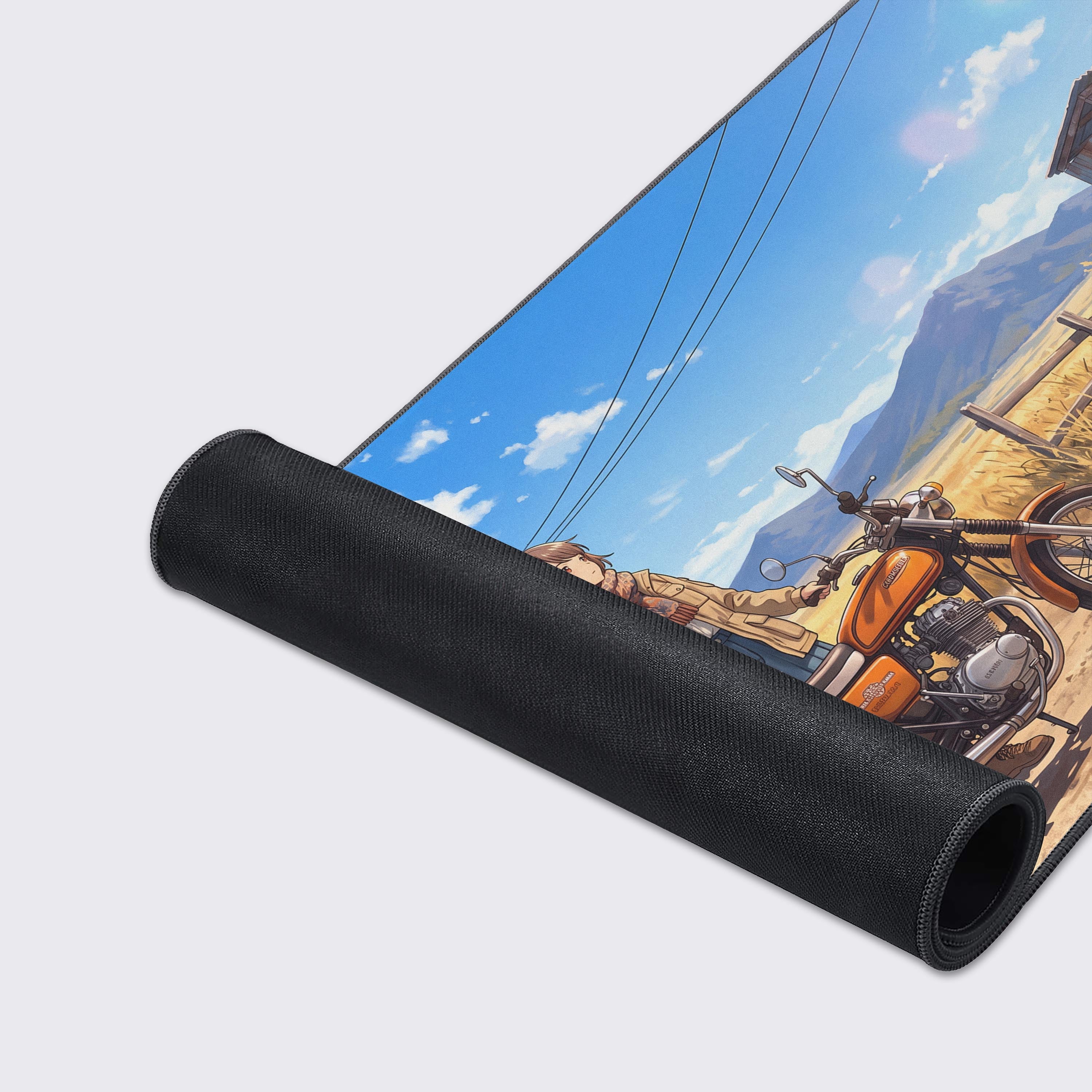 Detail view of the desk mat artwork showing golden fields, a wooden fence, and distant mountains beneath fluffy white clouds.