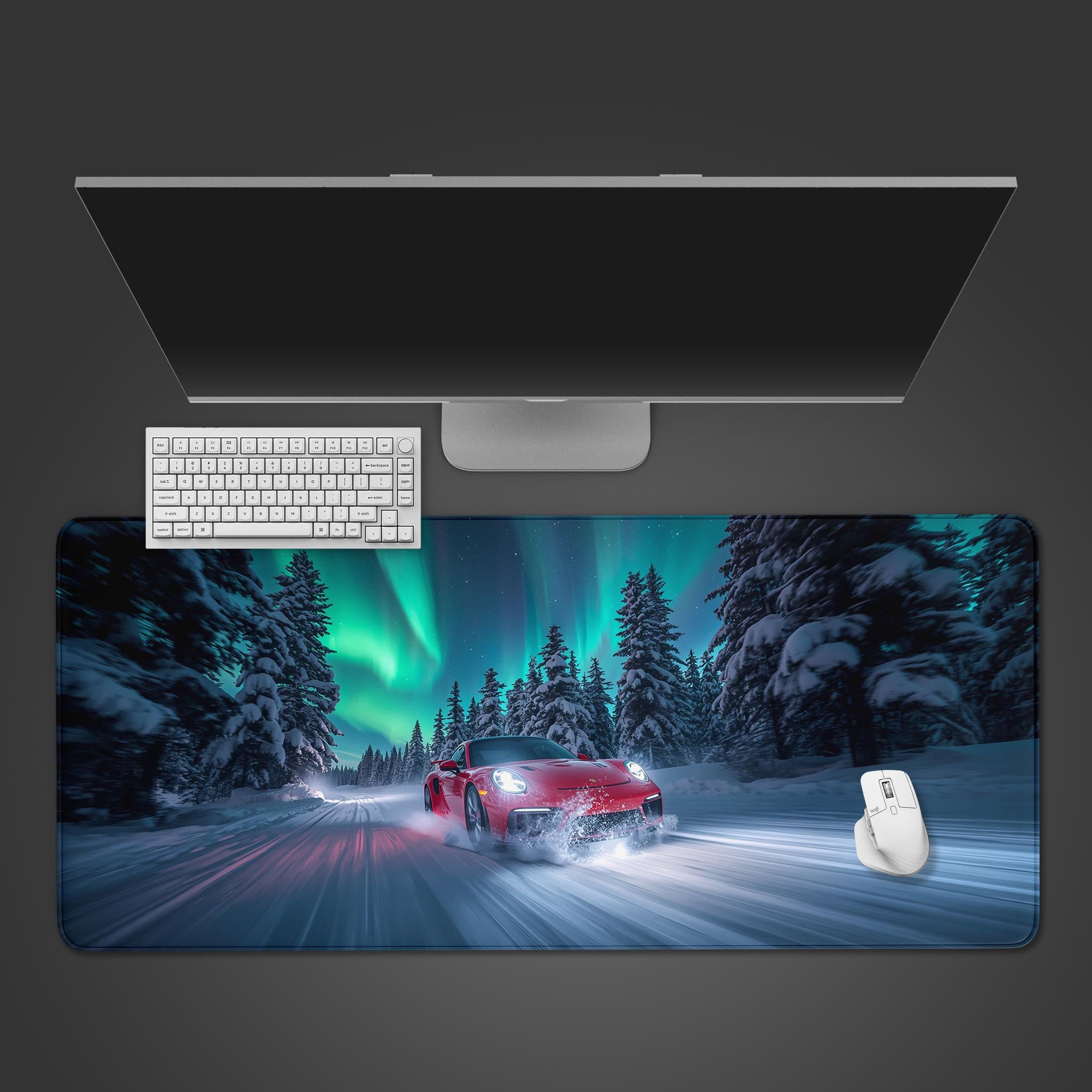 Northern Drive desk mat with a red sports car drifting in snow under the aurora borealis, shown on a desk with a keyboard and mouse. - Epic Design Pads