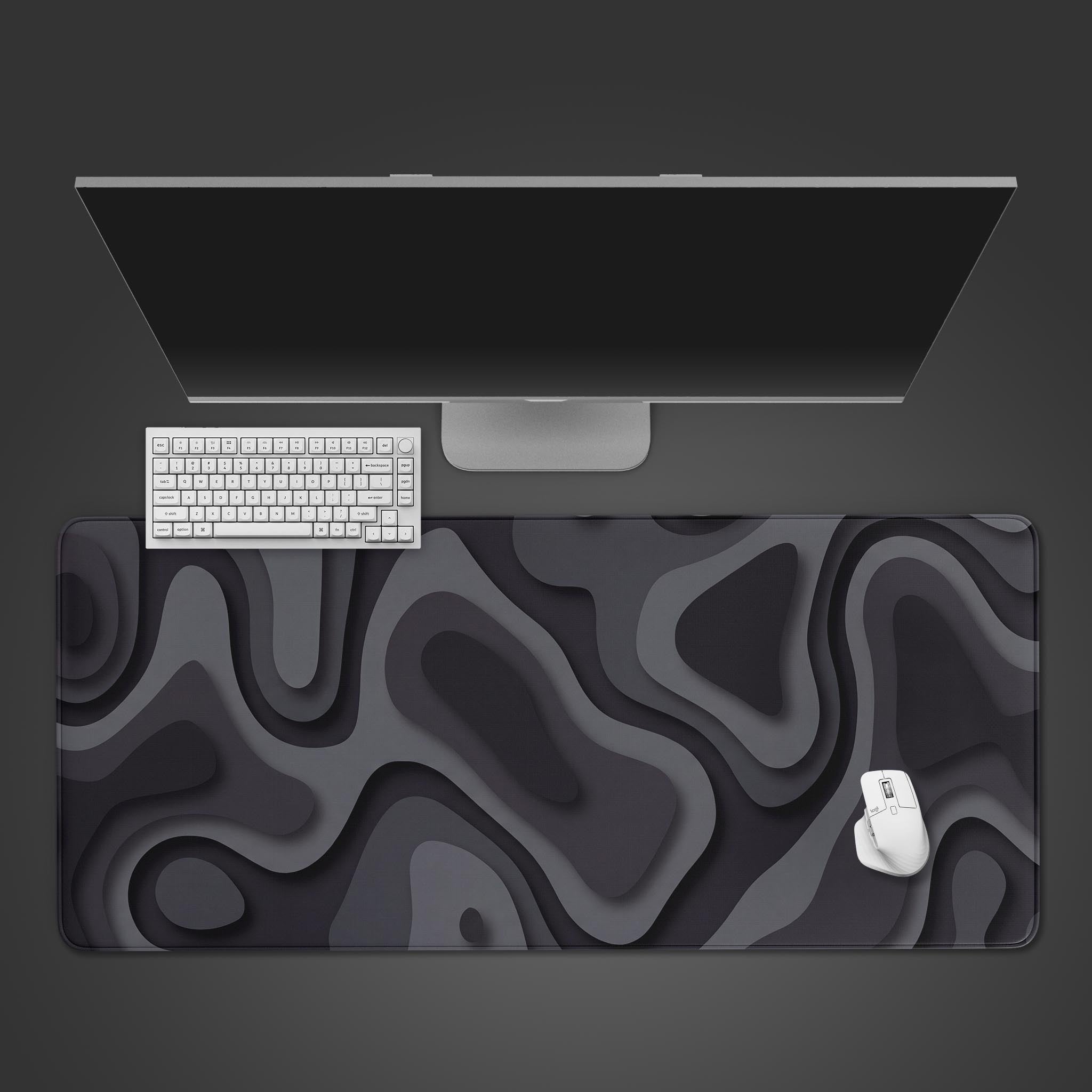 Top-down view of the Obsidian Strata gaming desk mat, featuring its abstract gray and black layered design. A white keyboard and mouse are placed on top. - Epic Design Pads & Mousepads