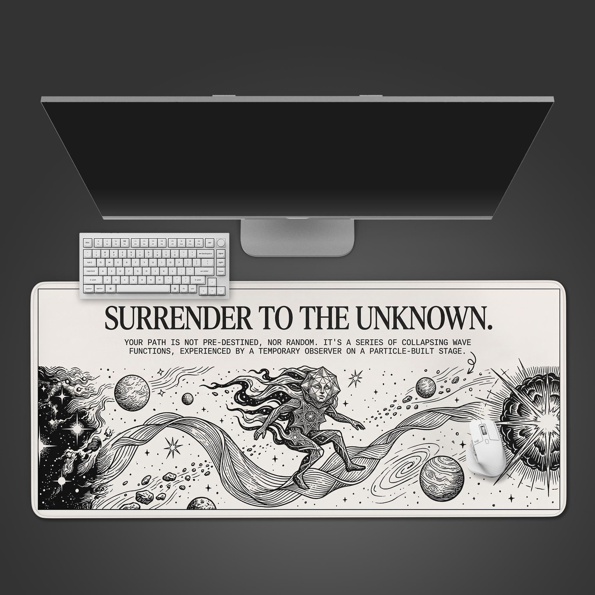 Top-down view of the "Quantum Surrender" gaming desk mat, featuring cosmic line art. A white keyboard and mouse are shown on the mat, below a large monitor. - Epic Design Pads & Mousepads