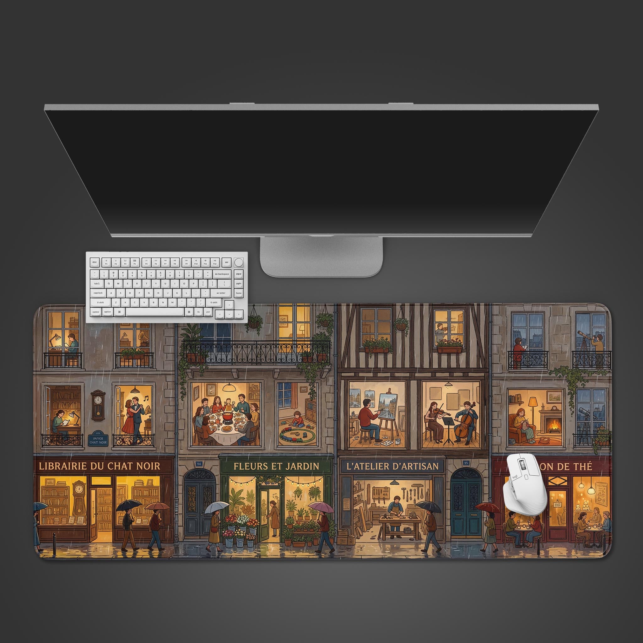 Top-down view of the Rainy Street Facade gaming desk mat, showing the cozy illustrated cityscape alongside a white keyboard, mouse, and a large monitor on a clean desk setup. - Epic Design Pads & Mousepads