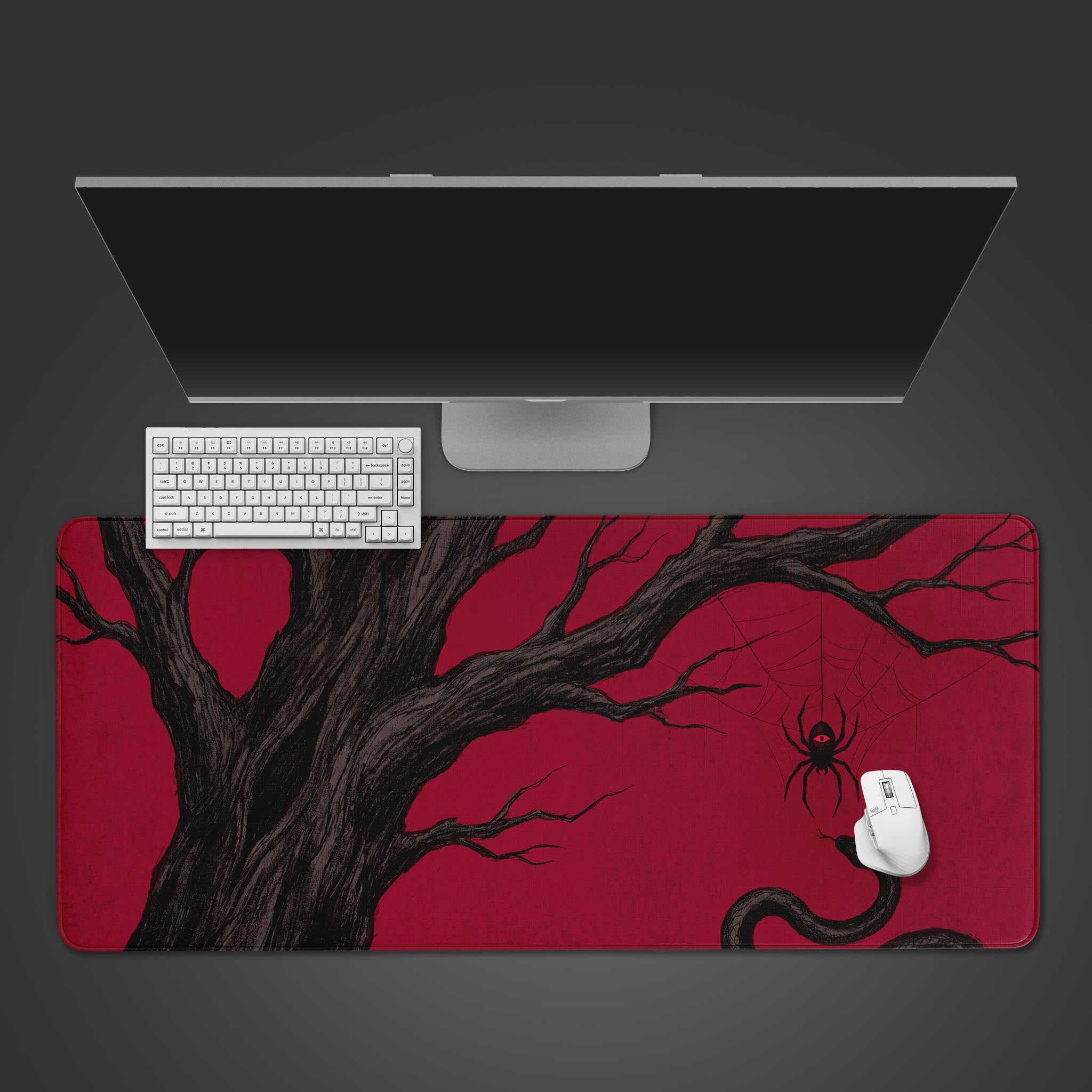 Red and black gothic desk mat featuring a dark gnarled tree, a descending spider, and a snake.