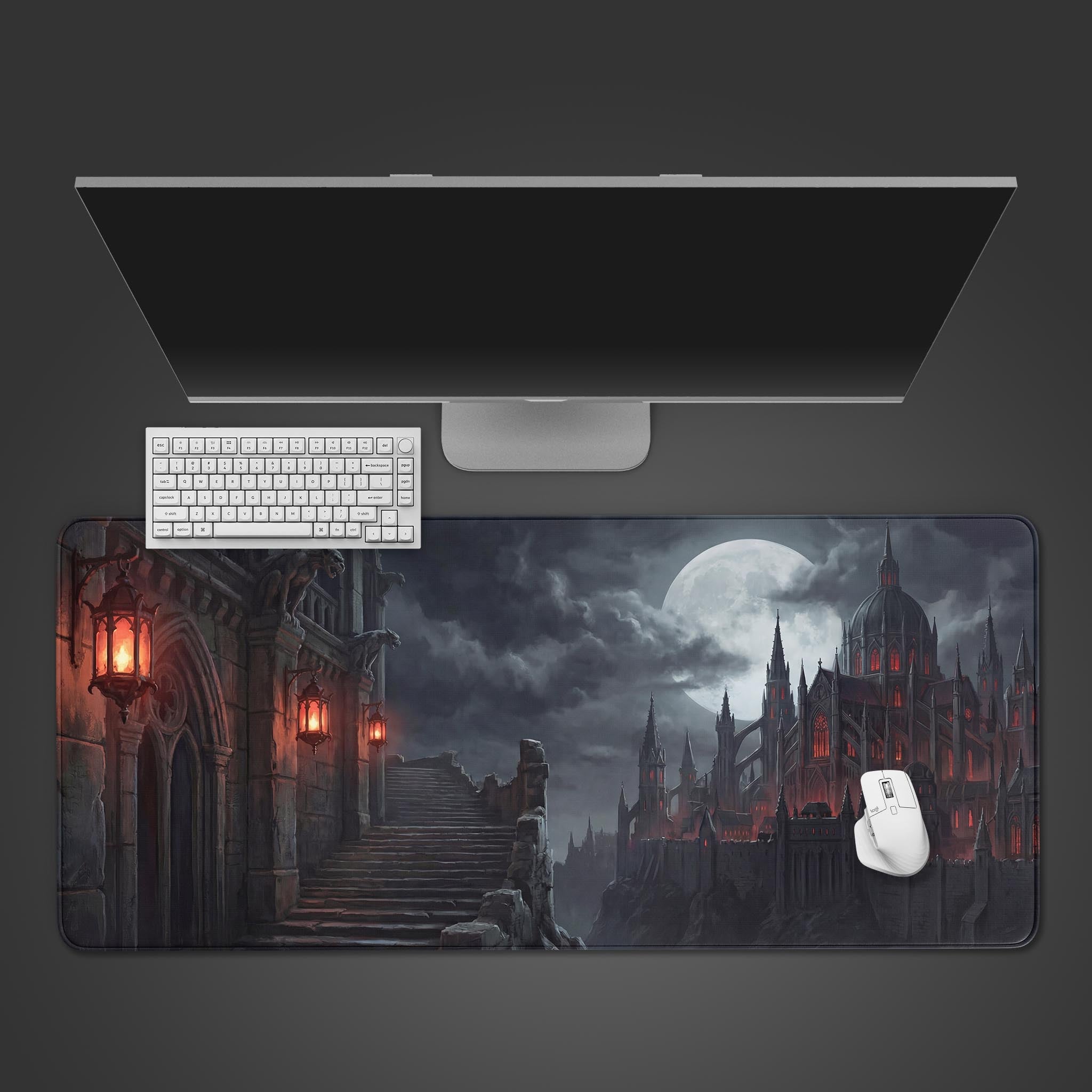 A top-down view of the Sanguine Keep gaming desk mat, featuring a gothic castle under a full moon, with a white keyboard and mouse neatly arranged on top. - Epic Design Pads & Mousepads