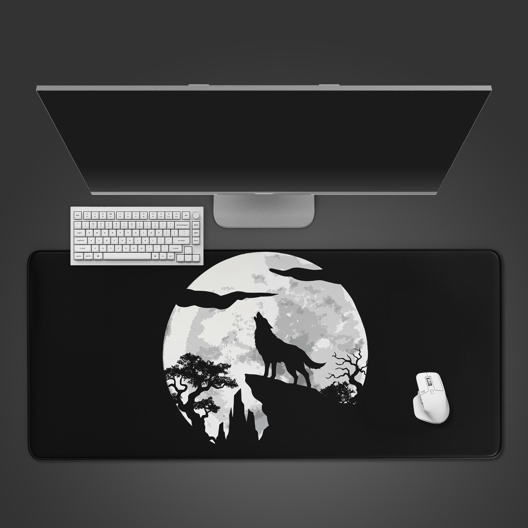 Top-down view of the Shadow Howl gaming desk mat featuring a wolf howling at the moon, shown with a white keyboard and mouse on a dark grey desk. - Epic Design Pads & Mousepads