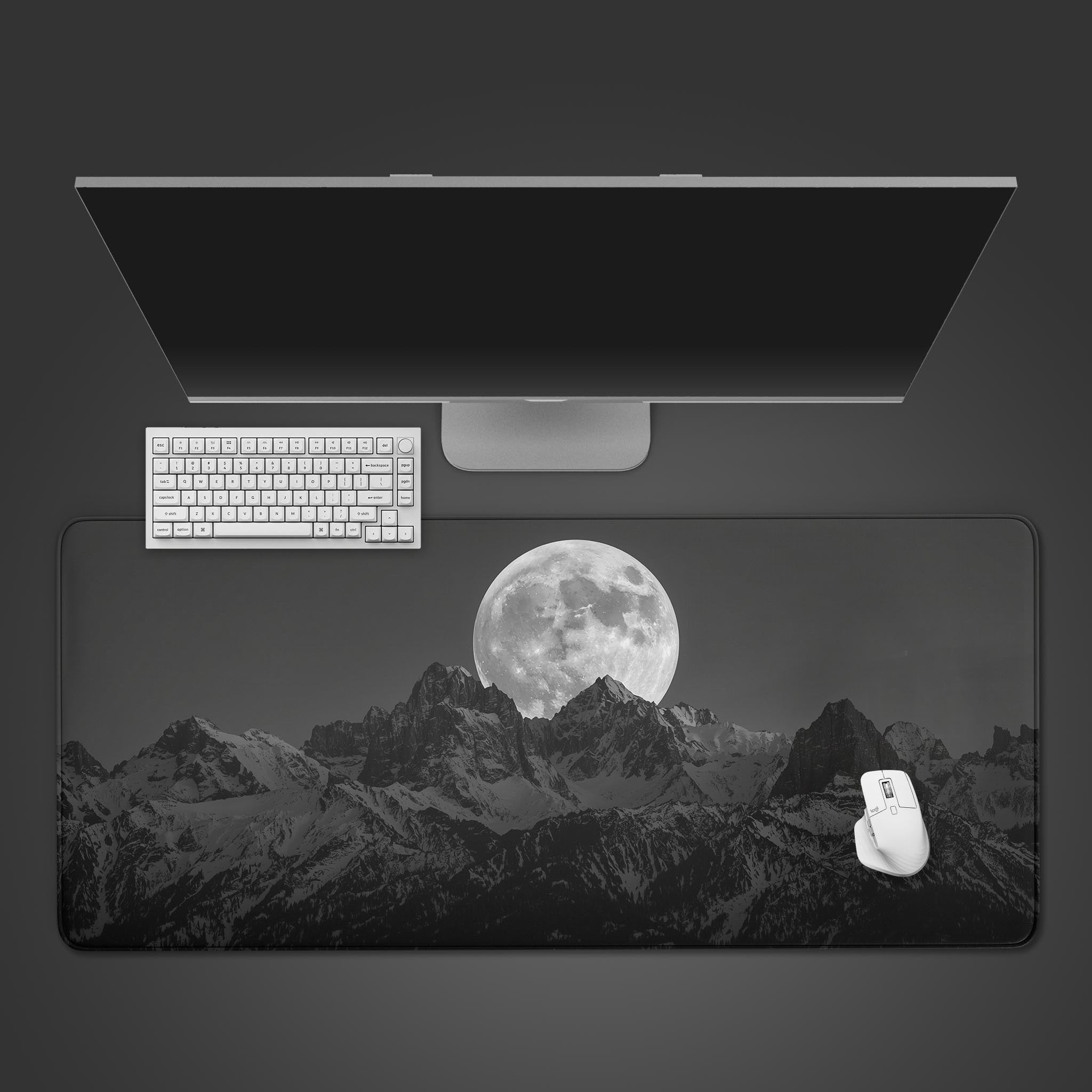 Monochrome mountain desk mat with a large moon design. Top-down view on a desk with a keyboard and mouse, showcasing the minimalist aesthetic. - Epic Design Pads