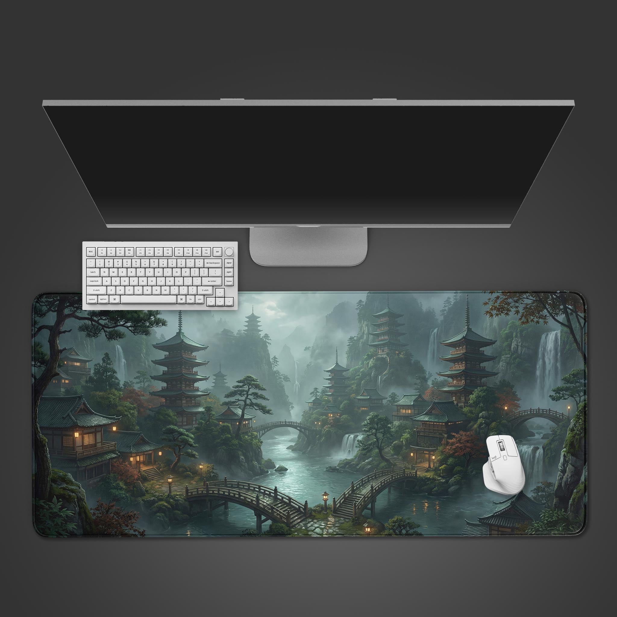 A top-down view of the Silent Pagoda gaming desk mat, featuring a Japanese landscape with pagodas. A white keyboard and mouse are placed on top, below a large monitor. - Epic Design Pads & Mousepads