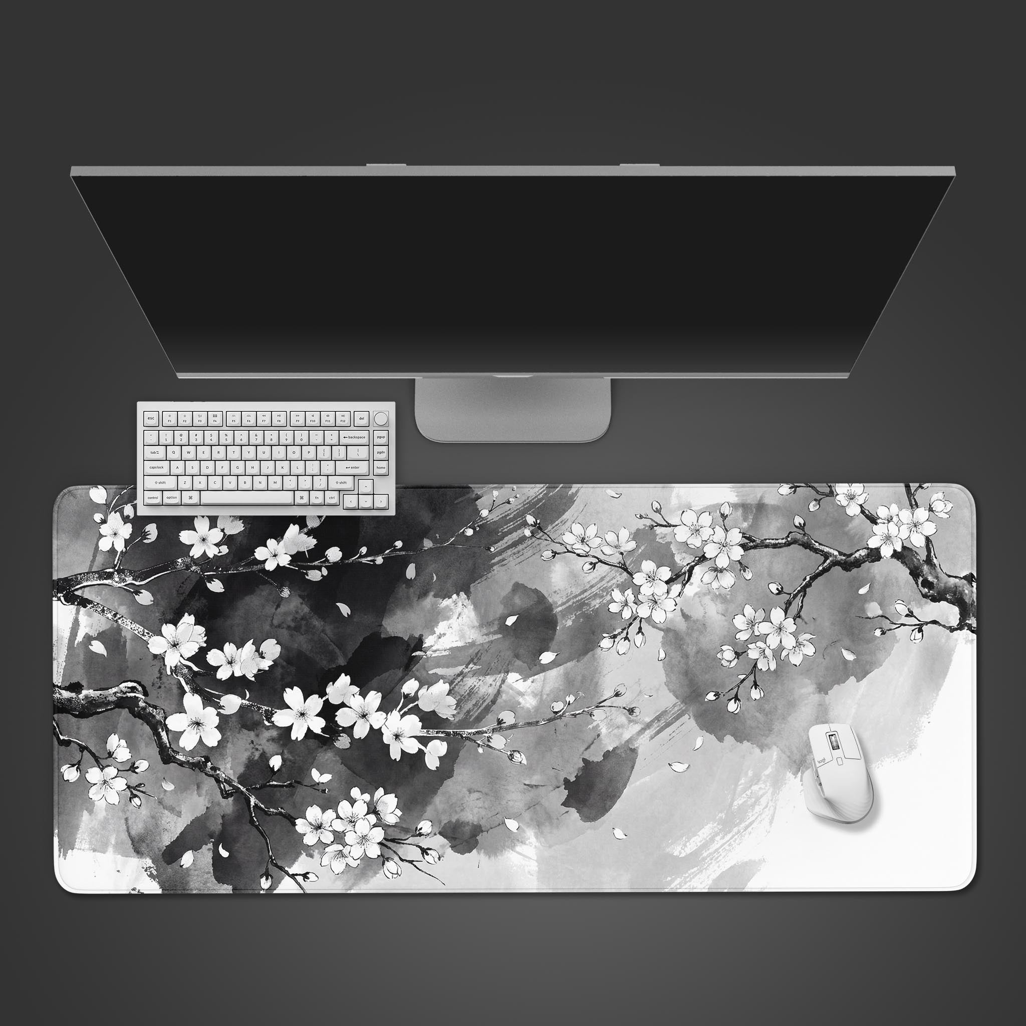 Top-down view of the Silent Sakura Gaming Desk Mat, featuring a Japanese ink wash cherry blossom design. A white keyboard and mouse are placed on the mat below a monitor. - Epic Design Pads & Mousepads