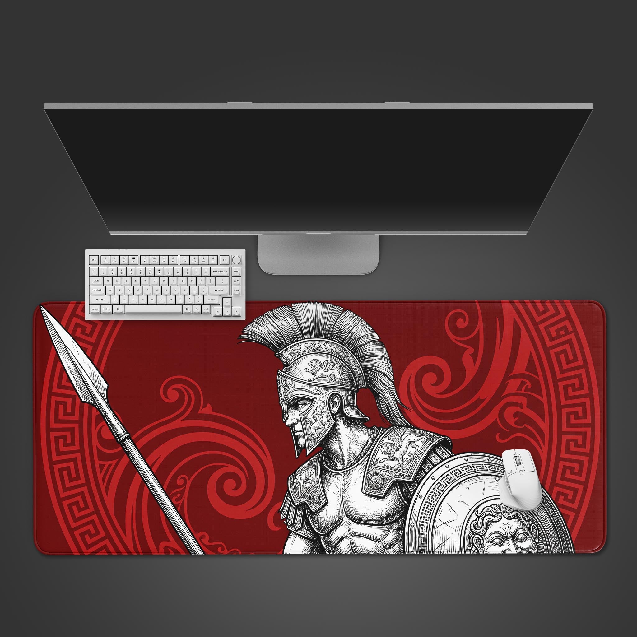 A top-down view of the Spartan Resolve gaming desk mat, showing the red and black Greek warrior design alongside a white keyboard and mouse on a dark desk. - Epic Design Pads & Mousepads