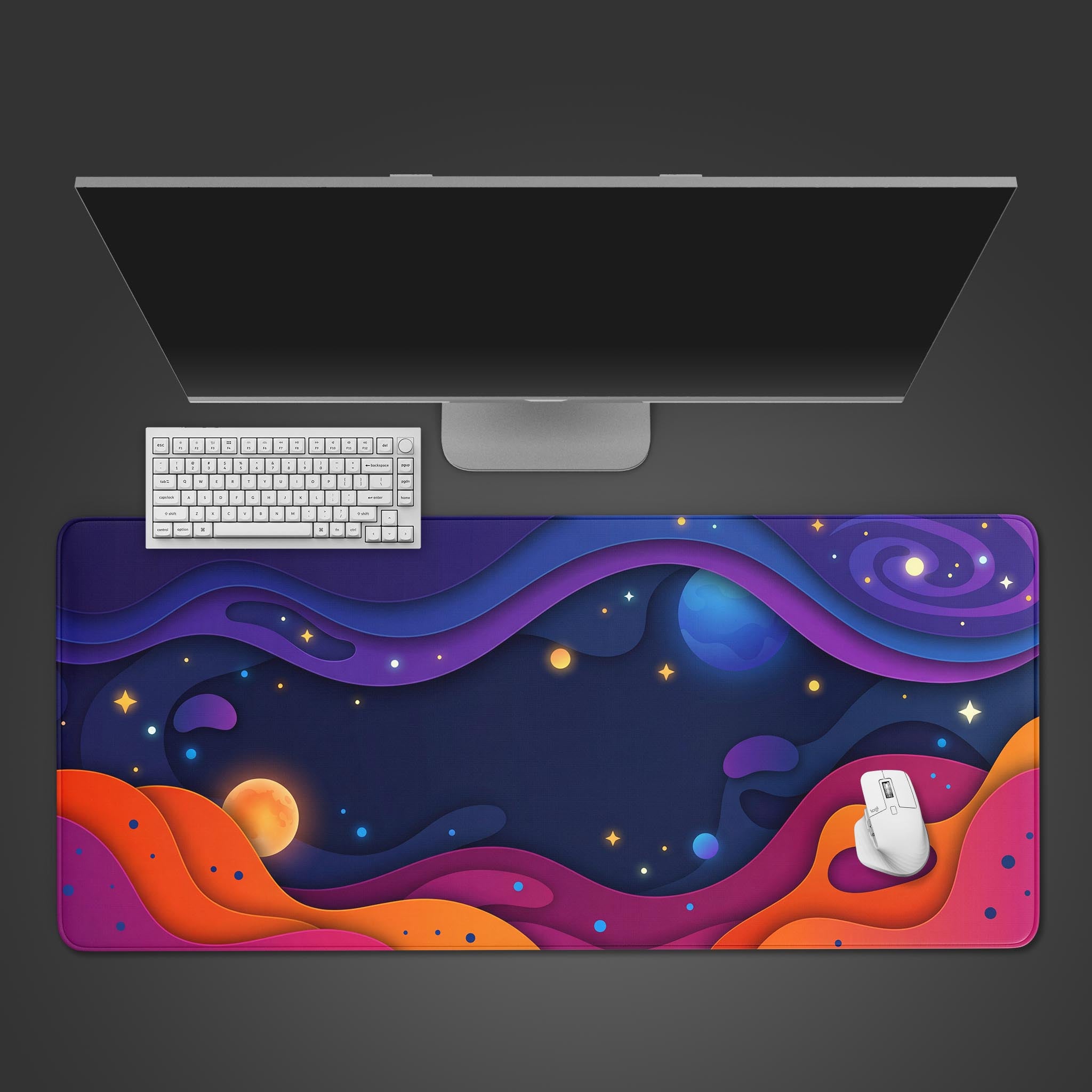 Top-down view of the Stellar Drift gaming desk mat featuring a colorful paper-cut space design, shown with a white keyboard and mouse under a monitor. - Epic Design Pads & Mousepads